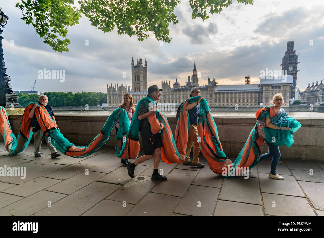 Londres, Royaume-Uni. 12 juillet 2018. Les militants climatiques portent une bannière géante de 100 mètres de longueur le long de la berge de la Tamise en face de la Chambre du Parlement où ils vont à l'afficher à l'occasion de la visite d'Atout au Royaume-Uni. La bannière a porté le message 'TRUMP : génocide climatique" en lettres orange fluorescent autour de 15m de haut. Ils disent qu'il est ignorant délibérément la science sur le changement climatique et menace l'existence même de la vie humaine sur terre en sapant si ce n'est pas renverser les nous et les efforts mondiaux pour lutter contre la plus grande menace que l'humanité fait face aujourd'hui, la déstabilisation catastrophique de glob Banque D'Images