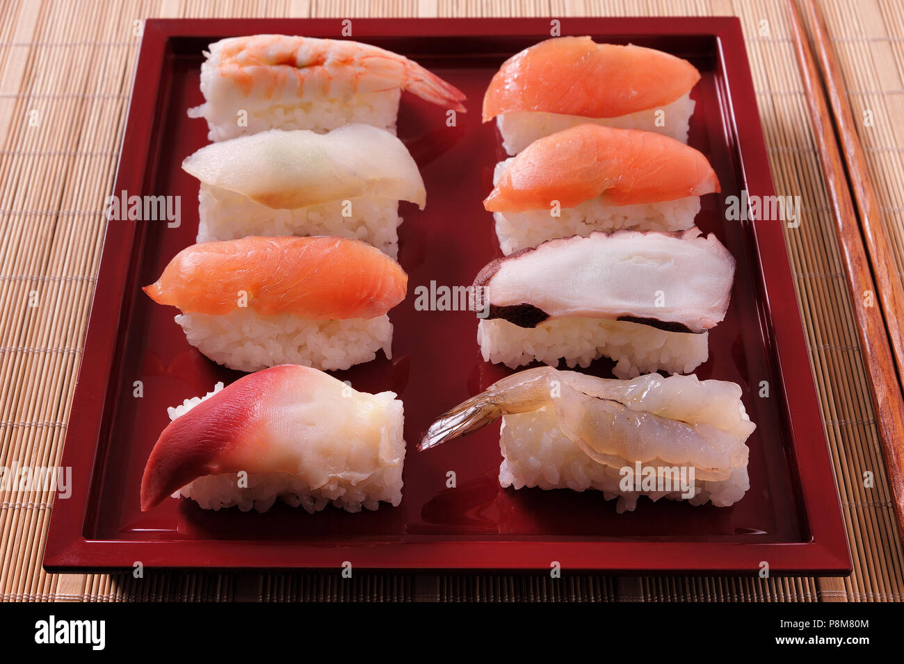 Sélection de sushis divers plaque rouge baguettes close up Banque D'Images