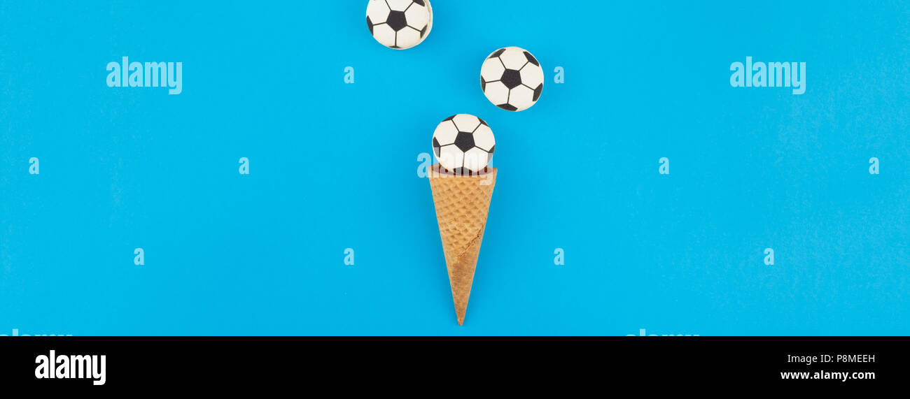 Bannière longue et large vue de dessus de la crème glacée cônes alvéolés avec des ballons de foot macarons sur fond bleu clair bold avec copie espace dans un style minimaliste, concep Banque D'Images