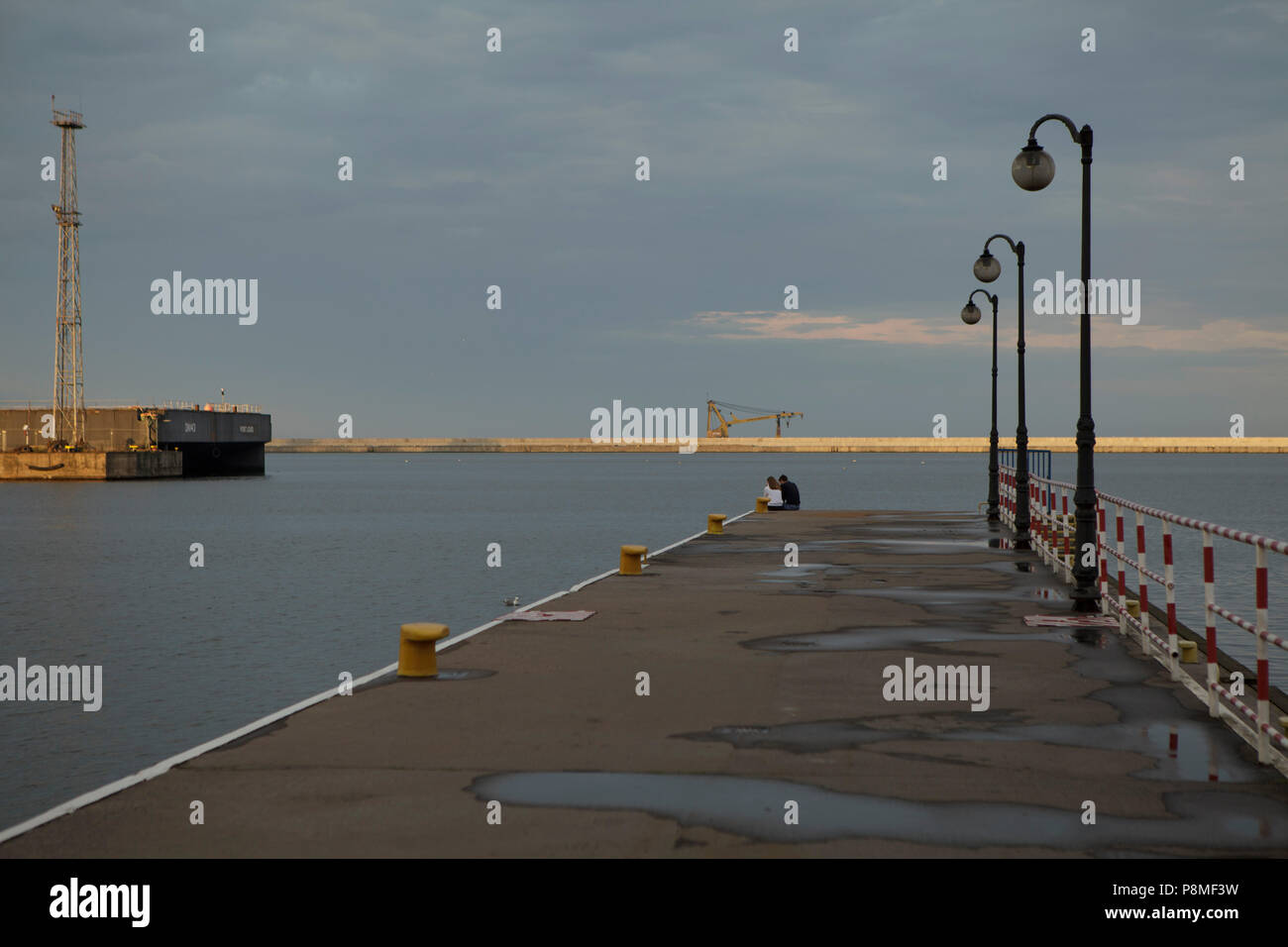 La jetée du port avec les lanternes dans le noir lumière du soir en été jour nuageux Banque D'Images