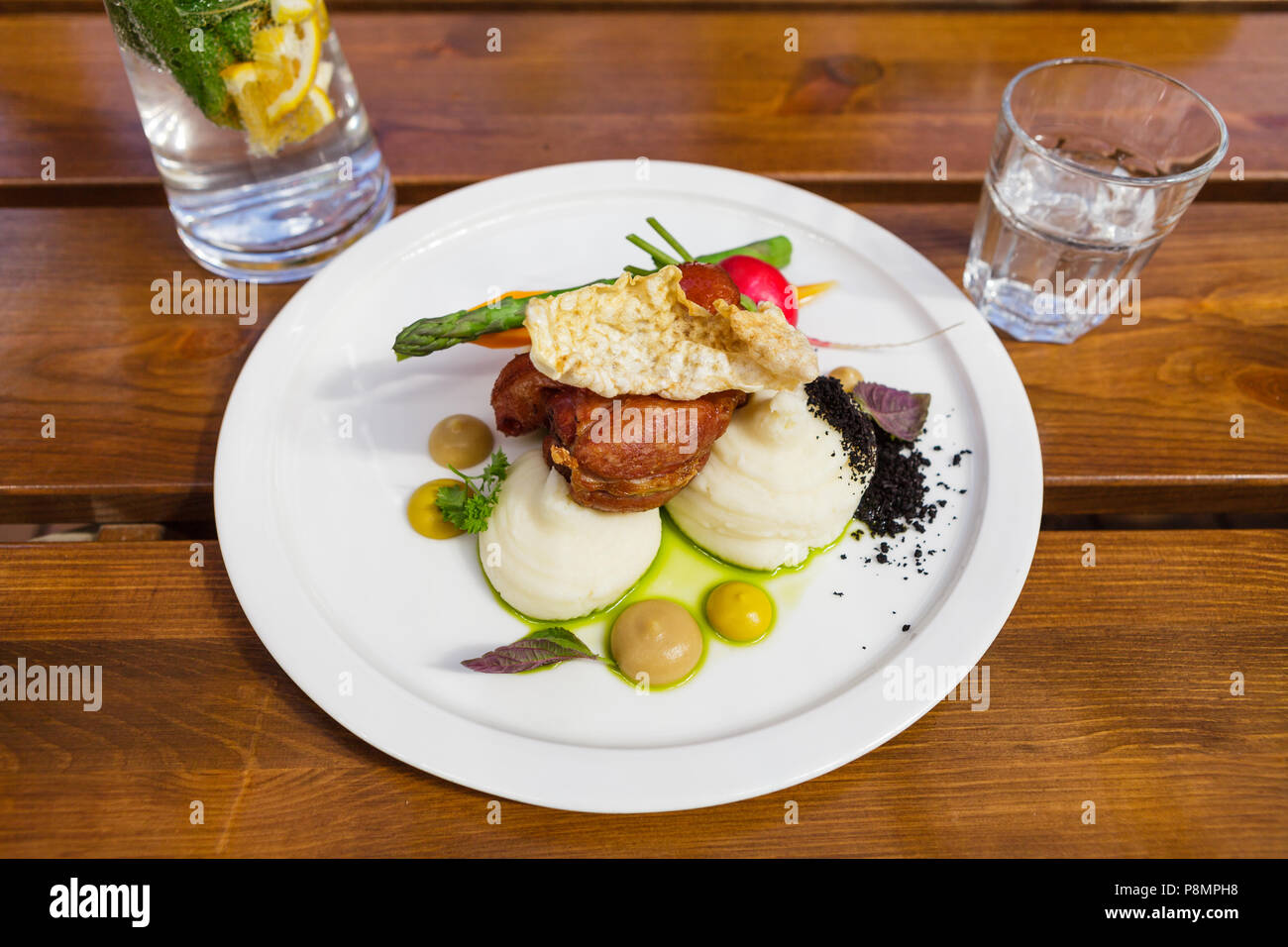 Jambonneau de porc avec purée de pommes de terre, légumes croquants, chips, moutarde, raifort et des olives noires du sol Banque D'Images