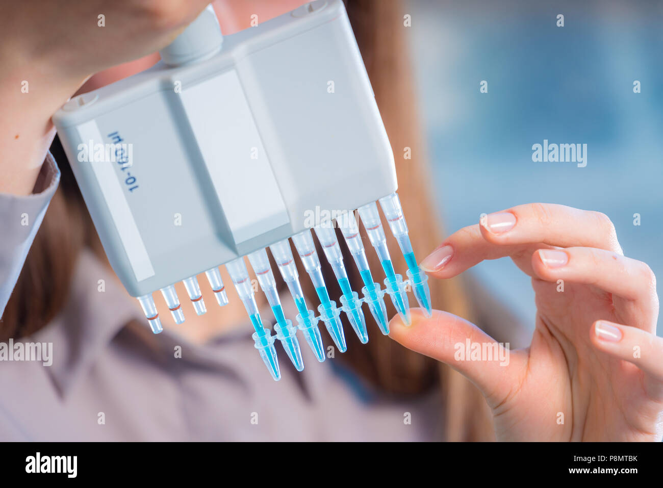 Chercheur en laboratoire microbiologique femme avec pipette multicanaux test ADN va Banque D'Images