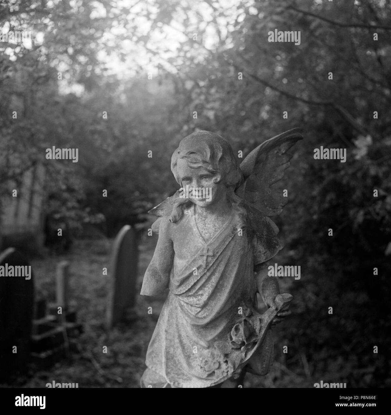 Statue d'un ange de l'enfant avec un bras manquant, le Cimetière de Highgate, Hampstead, Londres, 1987. Artiste : John Gay. Banque D'Images