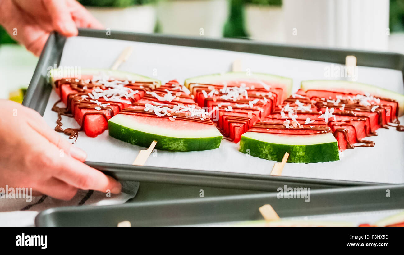 Étape par étape. Quartiers de pastèque garnie avec du chocolat et du sel de mer sur le stick sur une tôle à biscuits. Banque D'Images