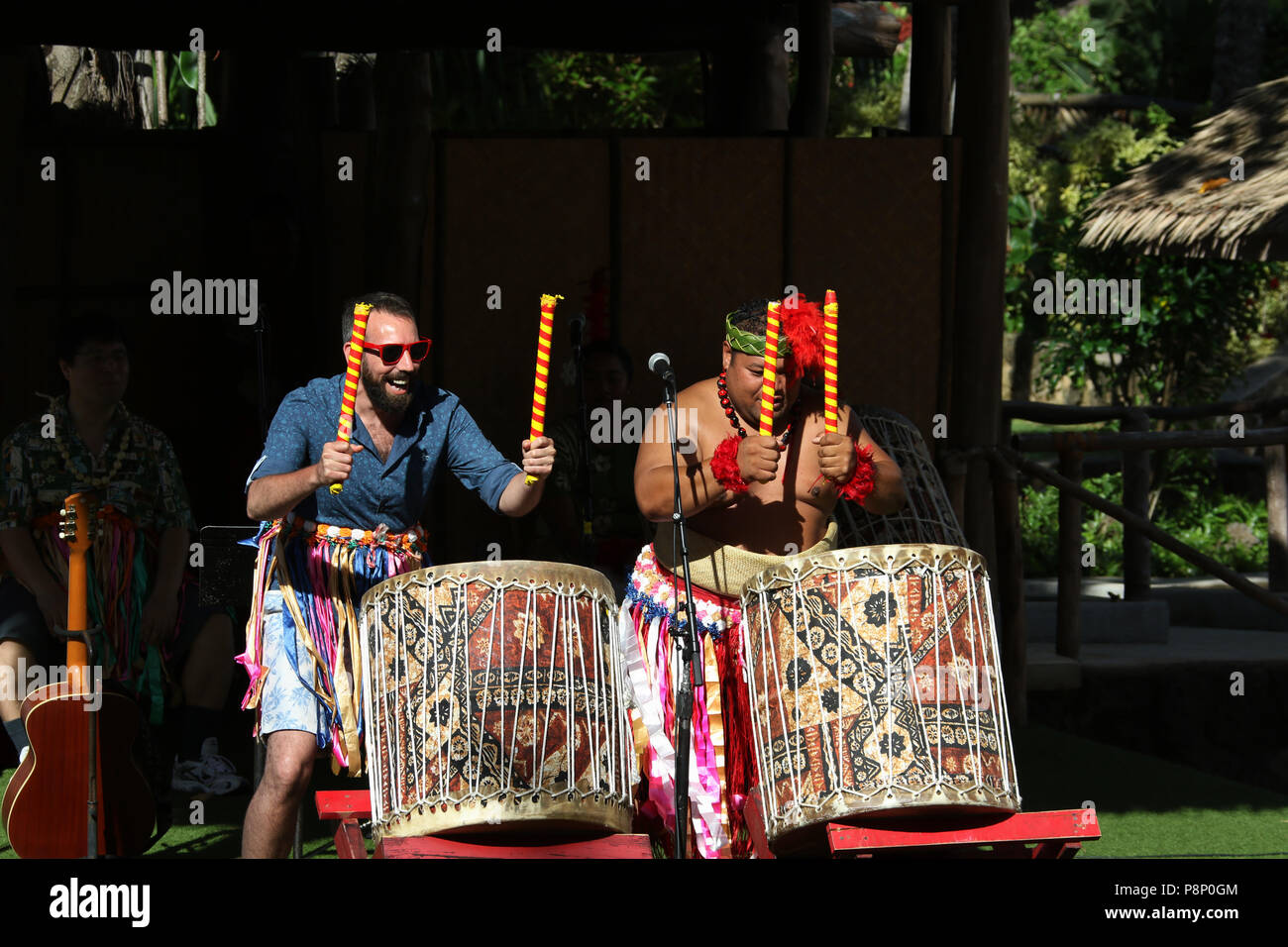 Dans le spectacle de tambour Tonga village. Un membre du public est en concurrence avec le maître. Centre Culturel Polynésien, Laie, Oahu, Hawaii, USA. Banque D'Images