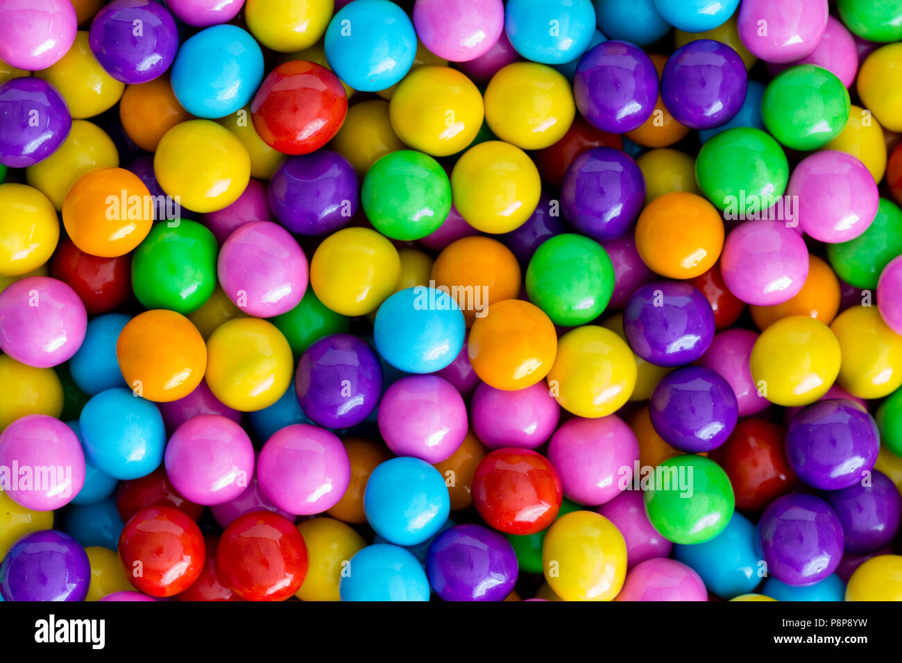 La texture de fond de couleur arc-en-ciel de perles ou de sucre candy sprinkles dans des couleurs vives utilisées pour la décoration en pâtisserie et en cuisine dans un cadre c Banque D'Images