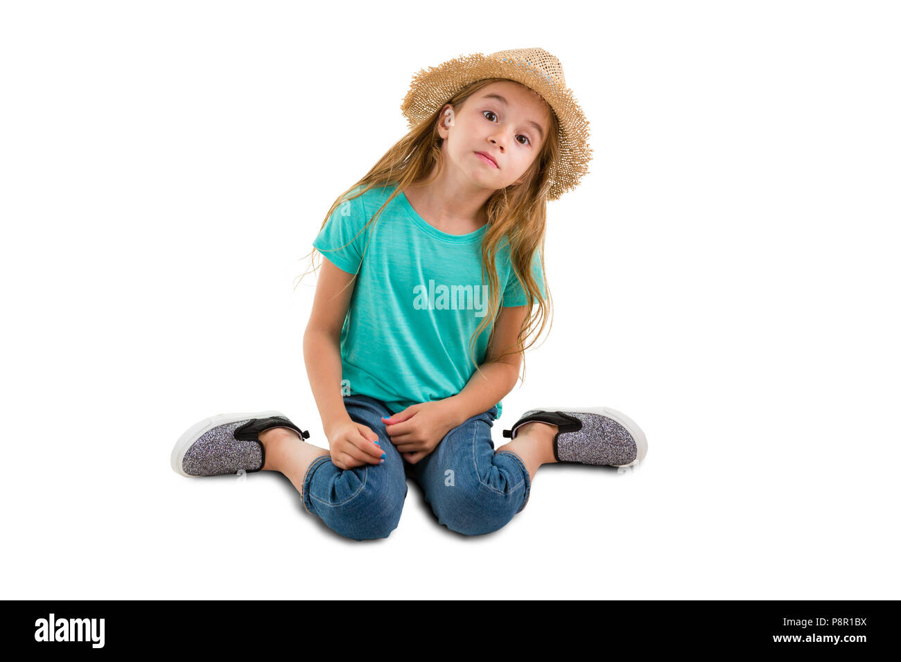 Petite fille assise souple accroupis sur le sol et en observant avec un appareil photo expression impudente comme s'attendant quelque chose, isolé sur whit Banque D'Images