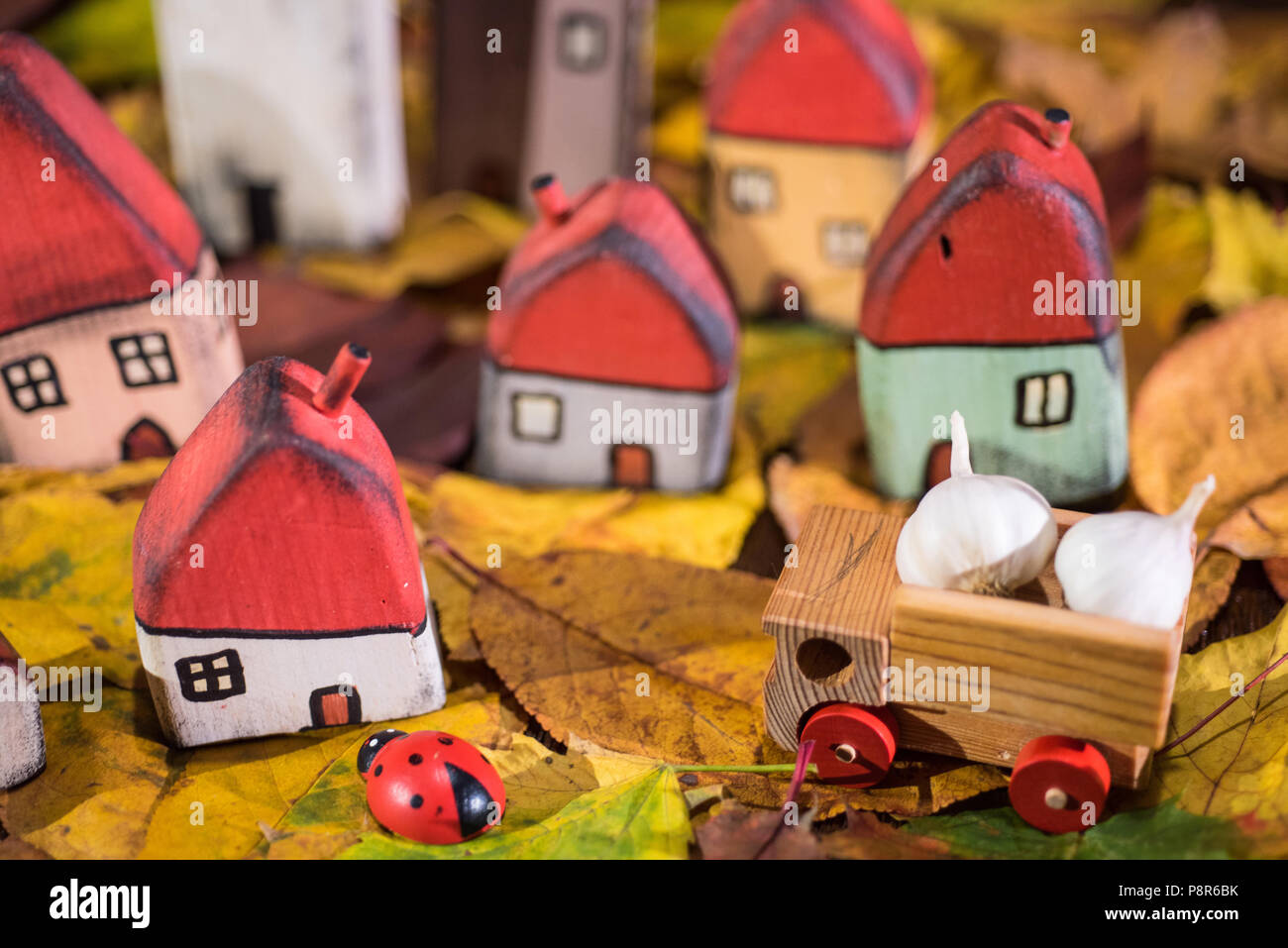 Aire de jeux pour les enfants, l'arrangement de jouet peint les maisons en bois, camion transportant de l'ail, coccinelle sur les feuilles d'automne. Concept de la petite enfance Banque D'Images