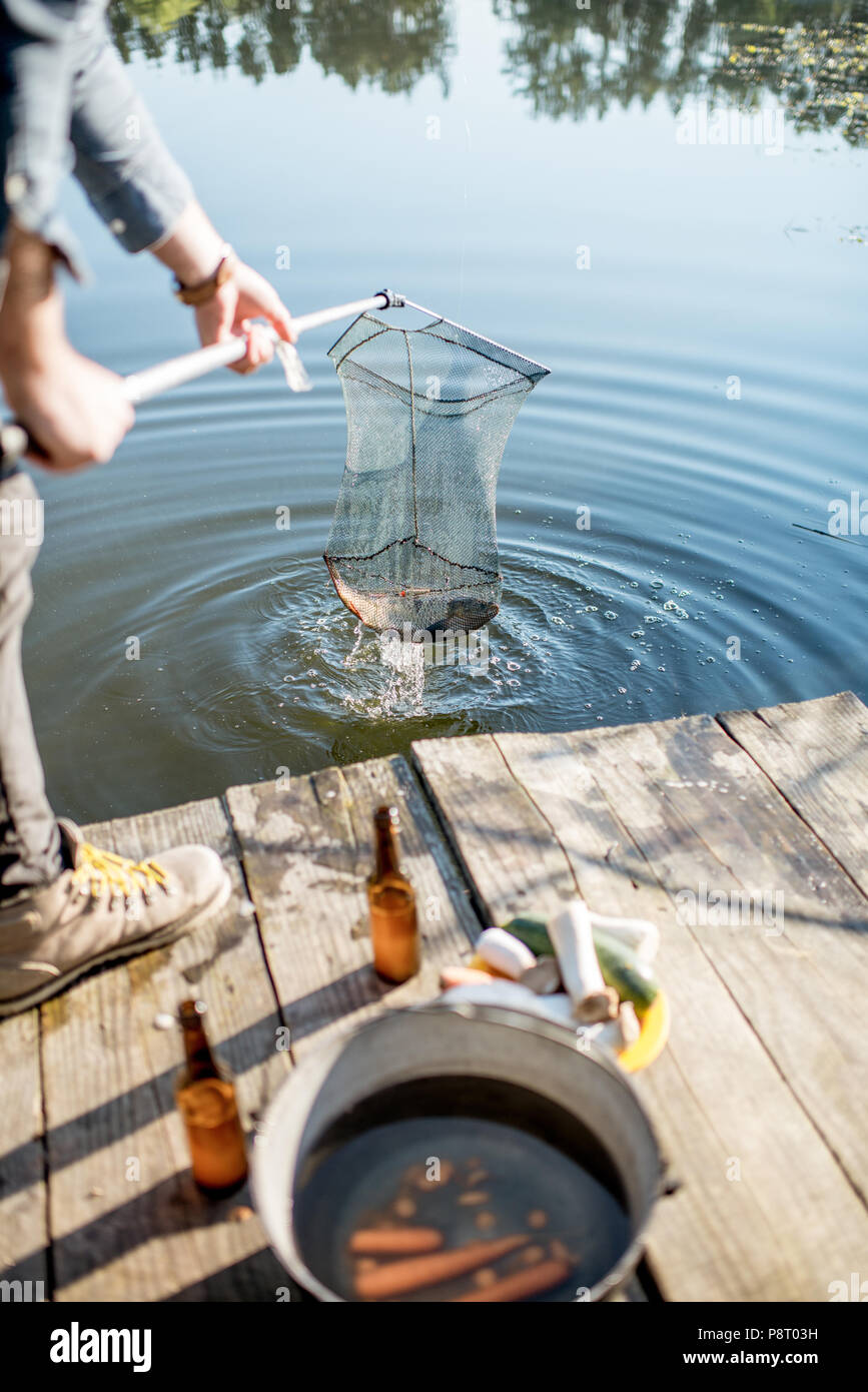 Pêcheur attraper de gros poissons avec filet de pêche sur le lac le matin Banque D'Images