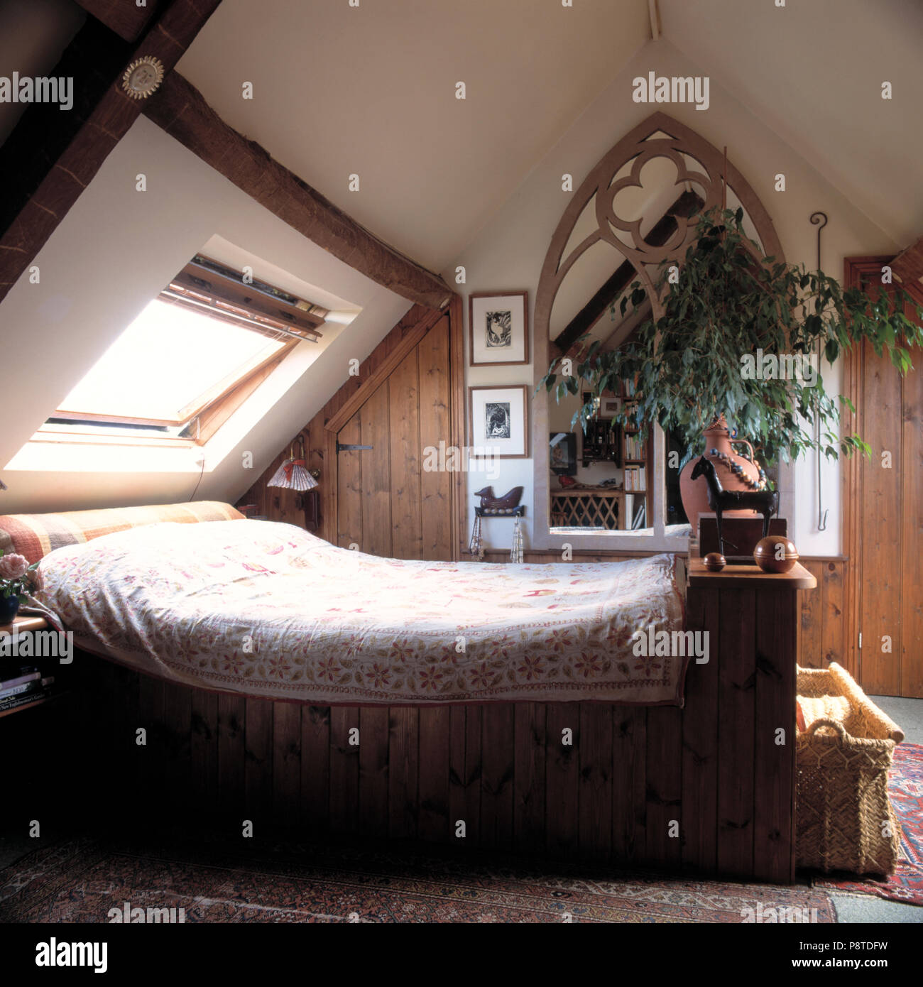Chambres ci-dessous fenêtre Velux dans une chambre mansardée avec plante en  face de miroir Gothique Photo Stock - Alamy