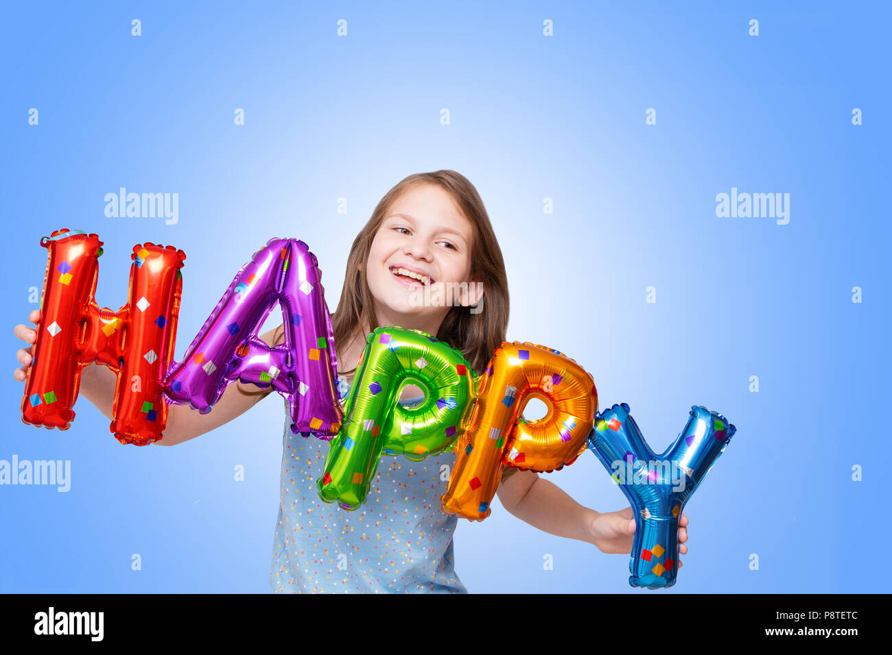 Cheerful girl avec des ballons anniversaire lettres Banque D'Images