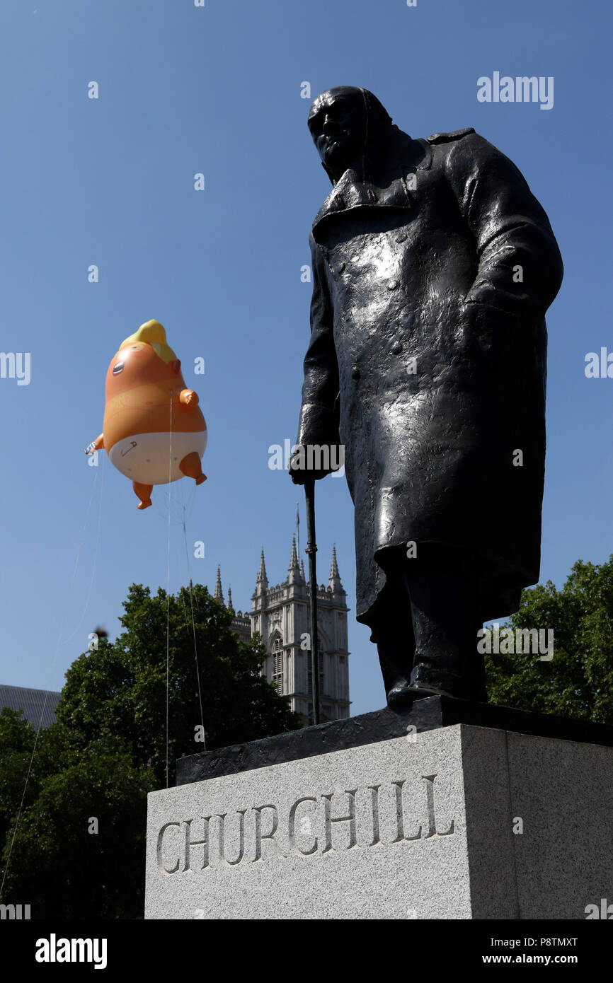 Londres, Royaume-Uni. Le 13 juillet, 2018. Un dirigeable, bébé Donald Trump , derrière la statue de Winston Churchill, vole au-dessus de Westminster Square à Londres, que le président des États-Unis d'Amérique visite London, et a rencontré le Premier ministre Theresa Mai et Sa Majesté la Reine Elizabeth II. L'atout de Donald baby blimp protestation, Londres, le 13 juillet 2018. Crédit : Paul Marriott/Alamy Live News Banque D'Images