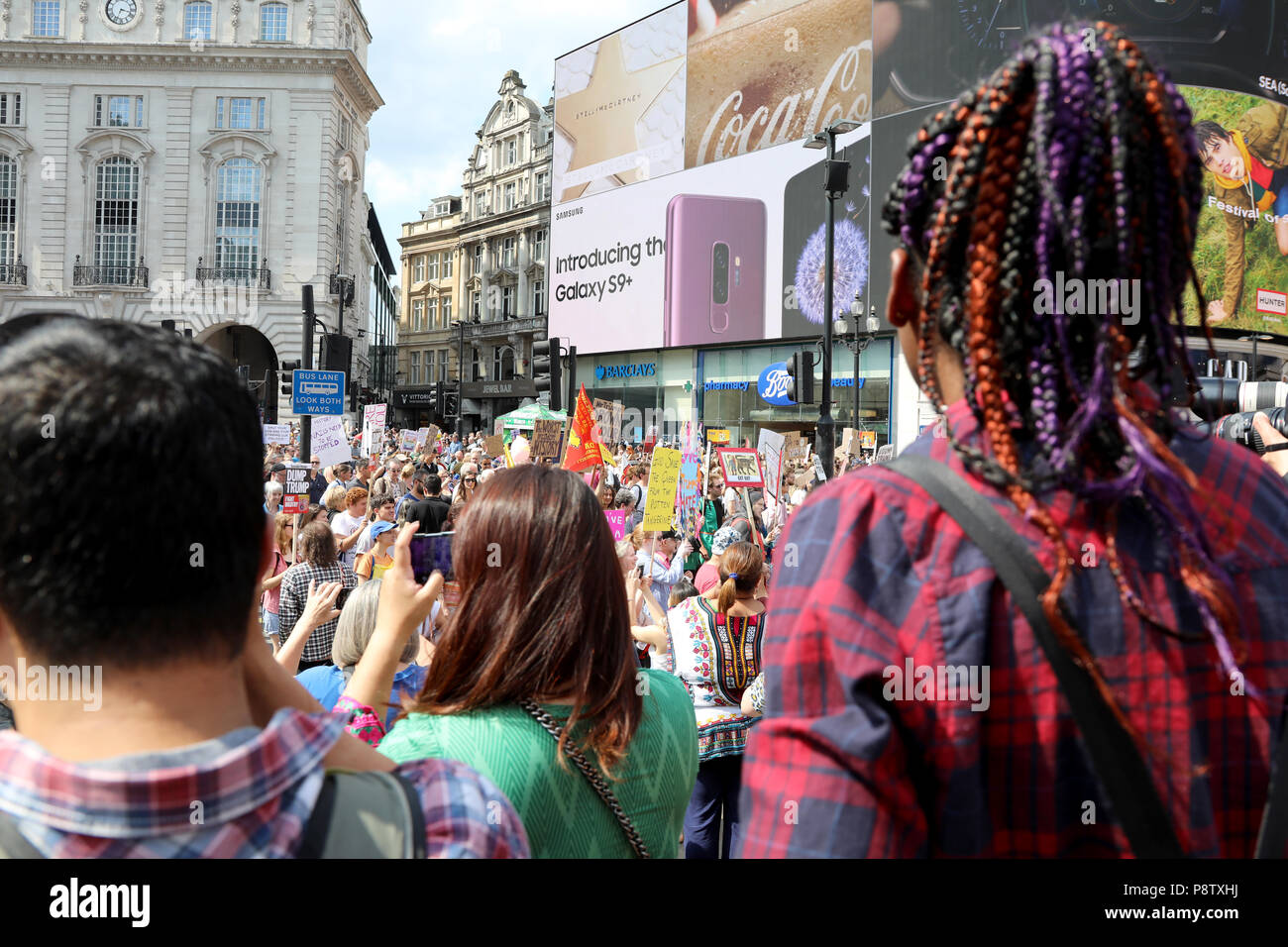 Londres, Royaume-Uni - 13 juillet 2018 : les spectateurs de regarder les étapes de l'Eros statue dans Piccadilly Circus, le centre de Londres, lors d'une manifestation pour protester contre le président américain, Donald Trump Crédit : Dominic Dudley/Alamy Live News Banque D'Images