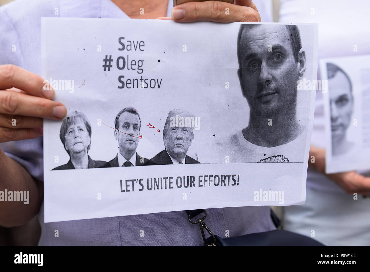 Une affiche avec des portraits de Chancelier allemand, Angela Merkel, le président français, Emmanuel Macron et États-Unis d'Amérique Président, Donald Trump pendant la manifestation. Protestation exigeant la libération du cinéaste et écrivain ukrainien, Oleg Sentsov à la place principale de Cracovie qui a été condamné à 20 ans pour complot en vue de commettre des actes de terreur. Banque D'Images