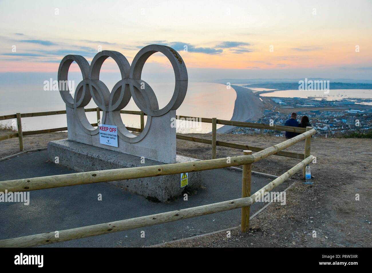 Portland Heights, à l'Île de Portland, Dorset, UK. 13 juillet 2018. Une sculpture de pierre de Portland Anneaux olympiques créé pour l'Jeux olympiques de 2012 à Londres a été clôturé à Portland Heights sur l'Île de Portland, dans le Dorset en raison de problèmes de sécurité il peut s'écrouler à cause de visiteurs de monter dessus. La sculpure était initialement situé à la gare la plus Wemouth au cours de la voile et a déménagé à son emplacement actuel après les Jeux Olympiques de 2012 a pris fin. Crédit photo : Graham Hunt/Alamy Live News Banque D'Images