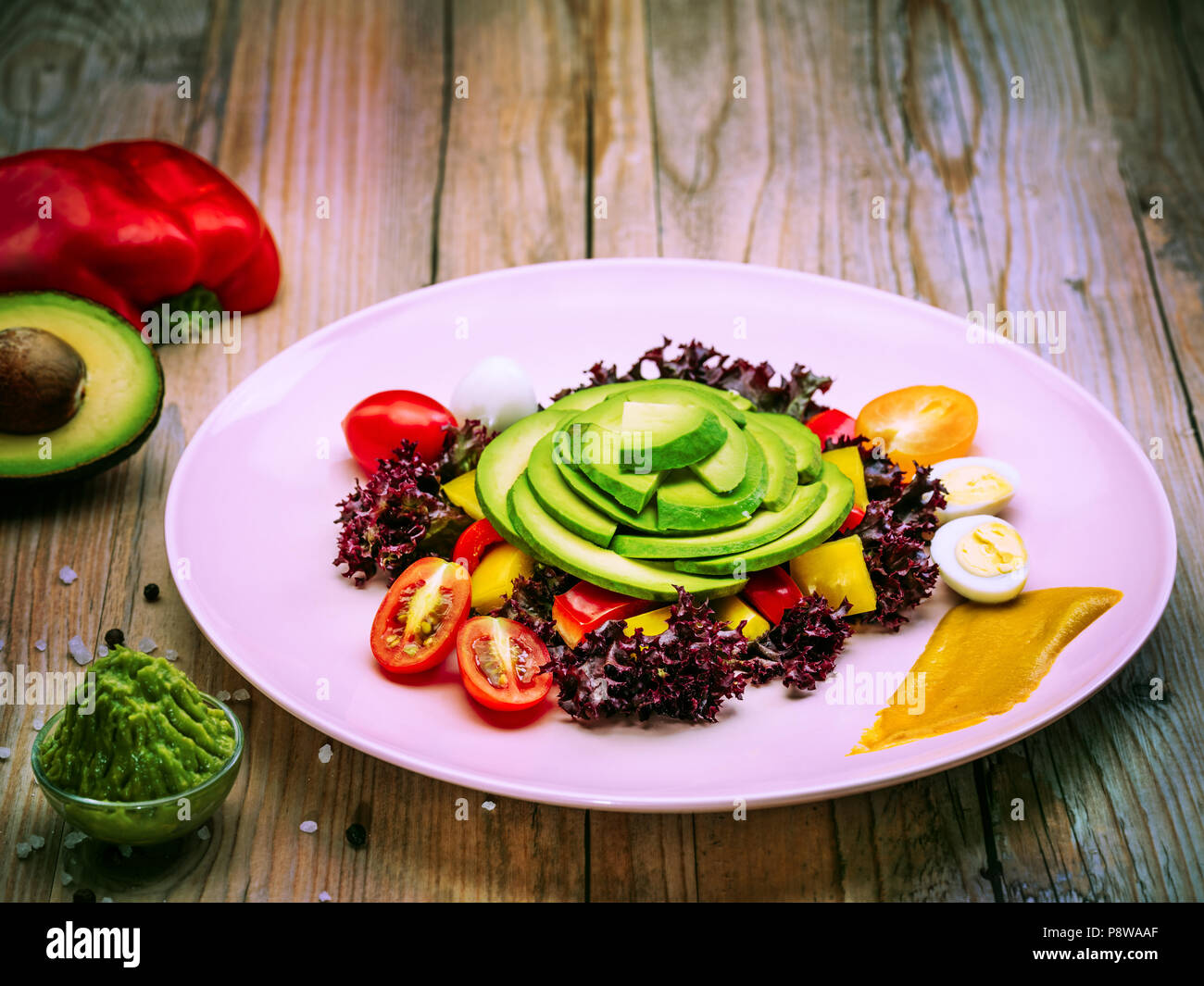 Salade d'alimentation avec des tomates cerises, des oeufs de cailles, jaune et le poivron rouge et la laitue. L'avocat est source de nutrition, de vitamines. Studio shot. Banque D'Images