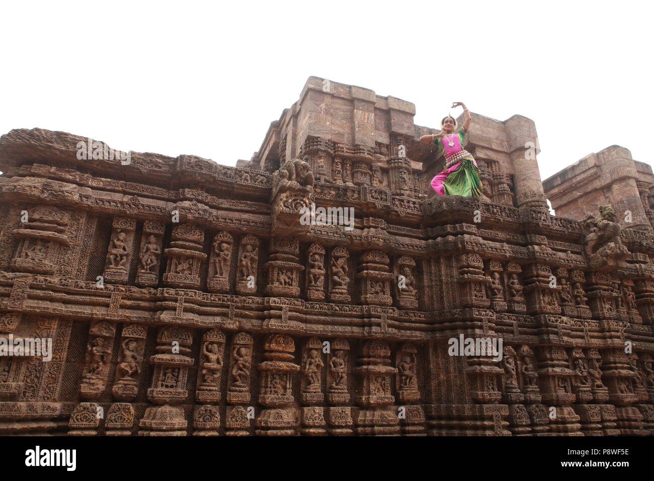 L'odissi est l'une des huit formes de danse classique de l'Inde, de l'état d'odisha.ici le danseur pose avant de temples avec sculptures Banque D'Images