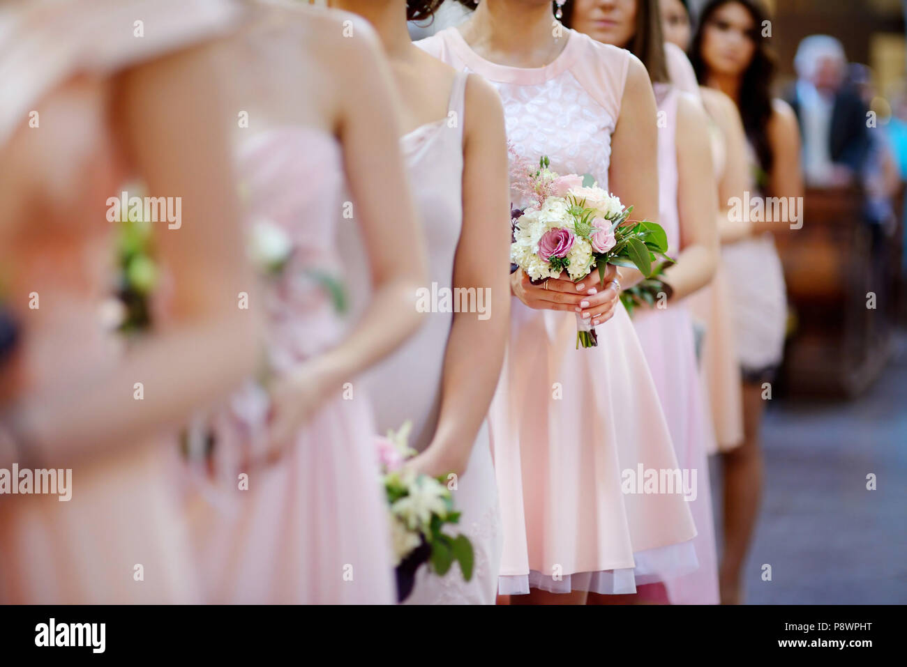 Rangée de demoiselles avec des bouquets à la cérémonie du mariage Banque D'Images