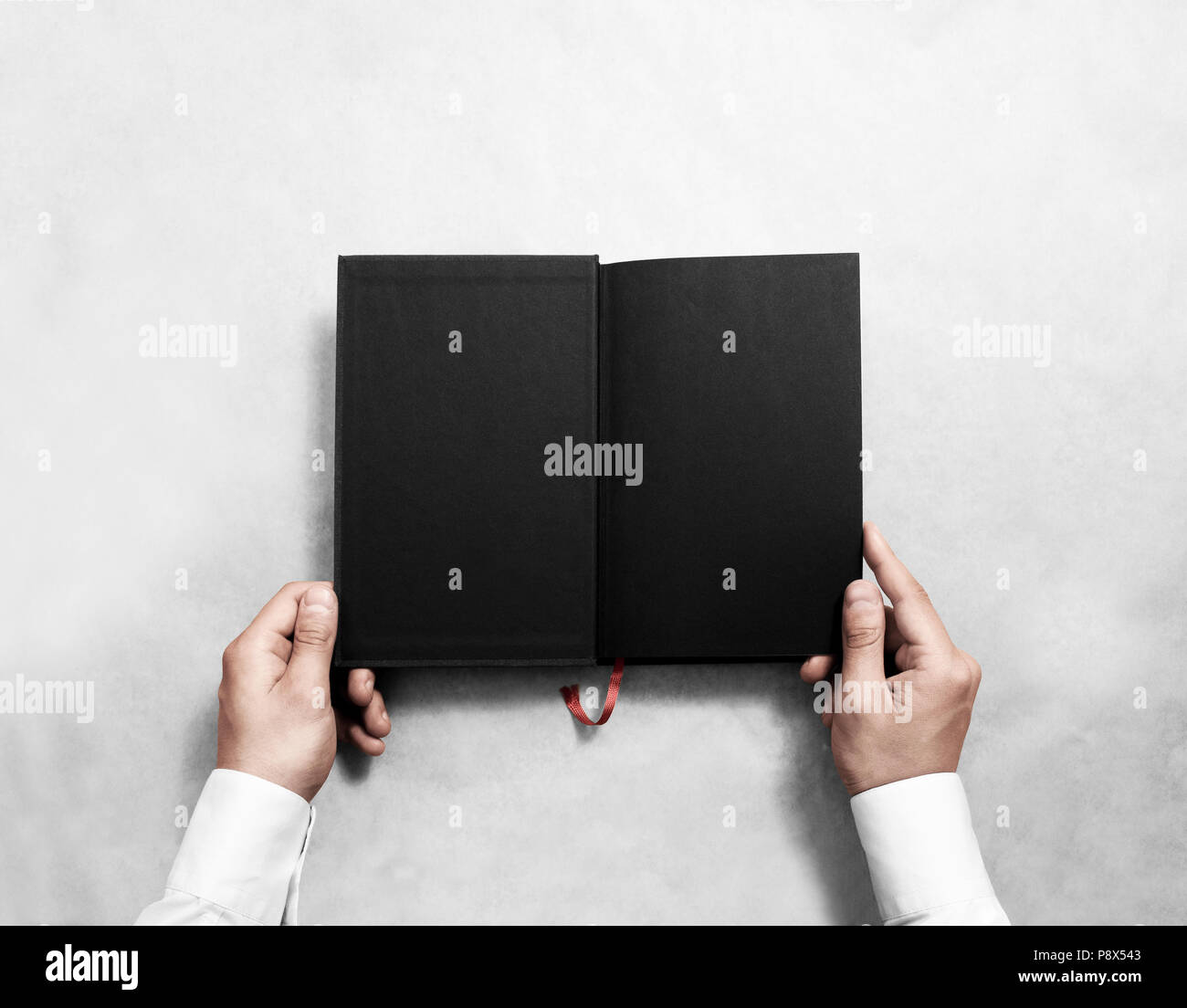 Hand holding blank maquette livre ouvert avec la moitié noire titre. Personne lecture poche vide immersive. Ordinateur portable noir à l'intérieur de modèle. Publication desig Banque D'Images