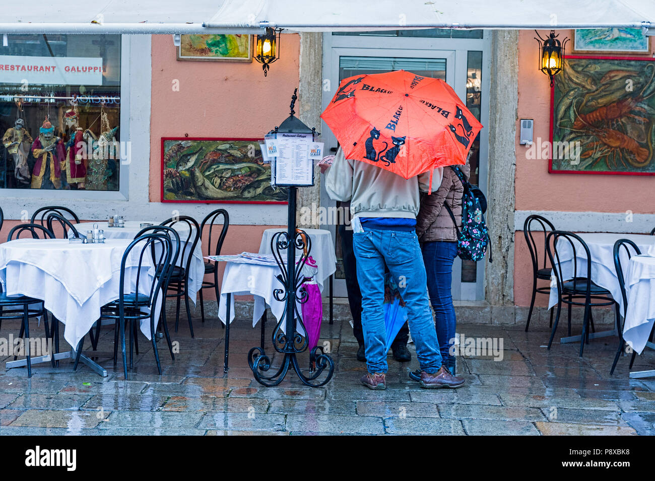 Deux hommes debout sous la pluie, Burano, Italie Banque D'Images