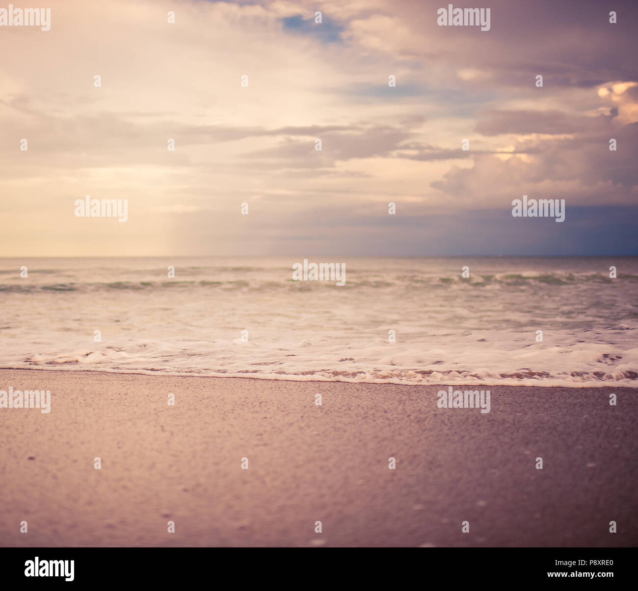 Gros plan Vintage square sunset beach avec de beaux paysage sable brun texturé, un léger reflet du soleil du soir et douce vagues écumeuses Banque D'Images