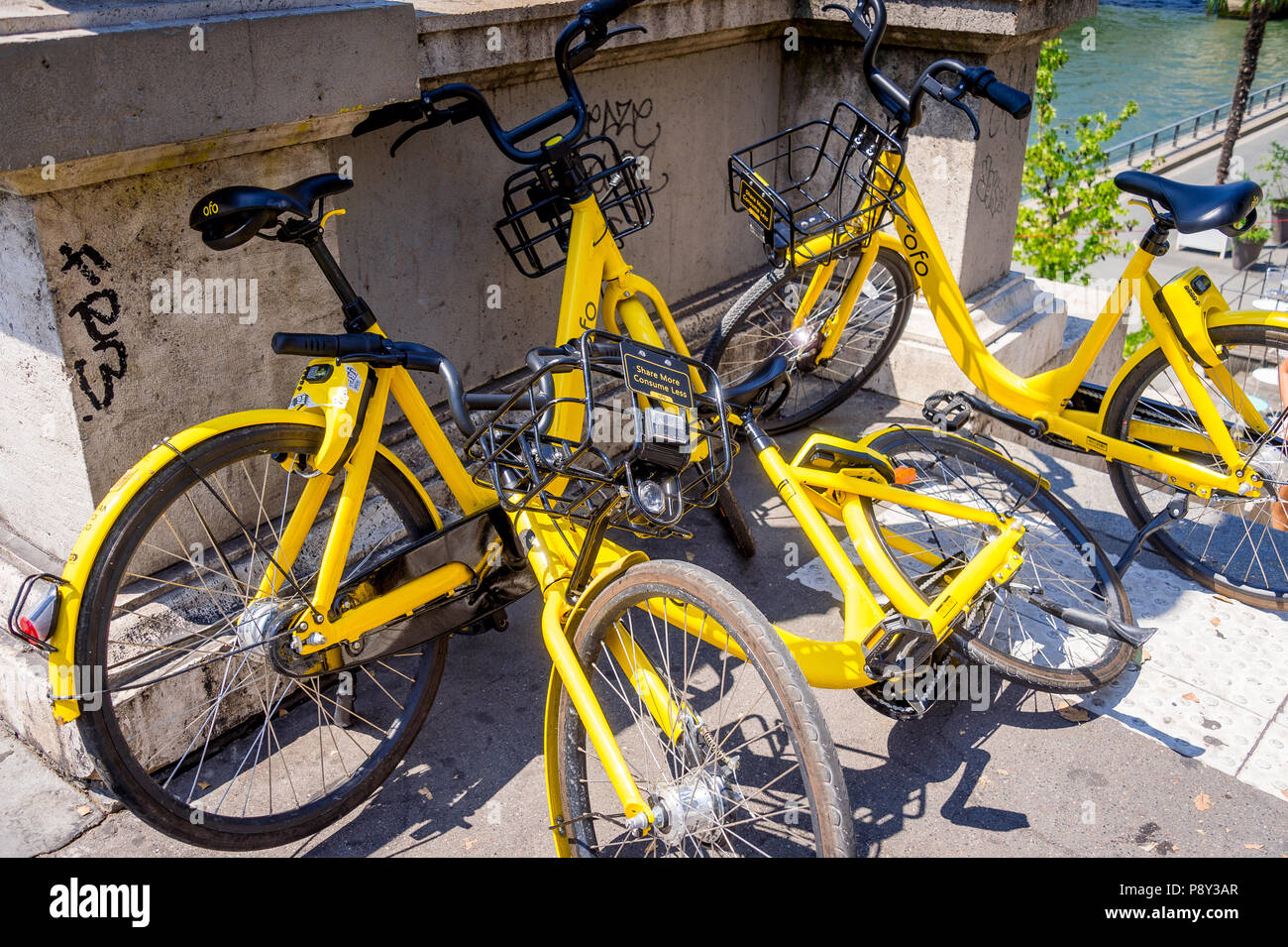 Trois Ofo ride partager des vélos sur une rue de Paris Banque D'Images