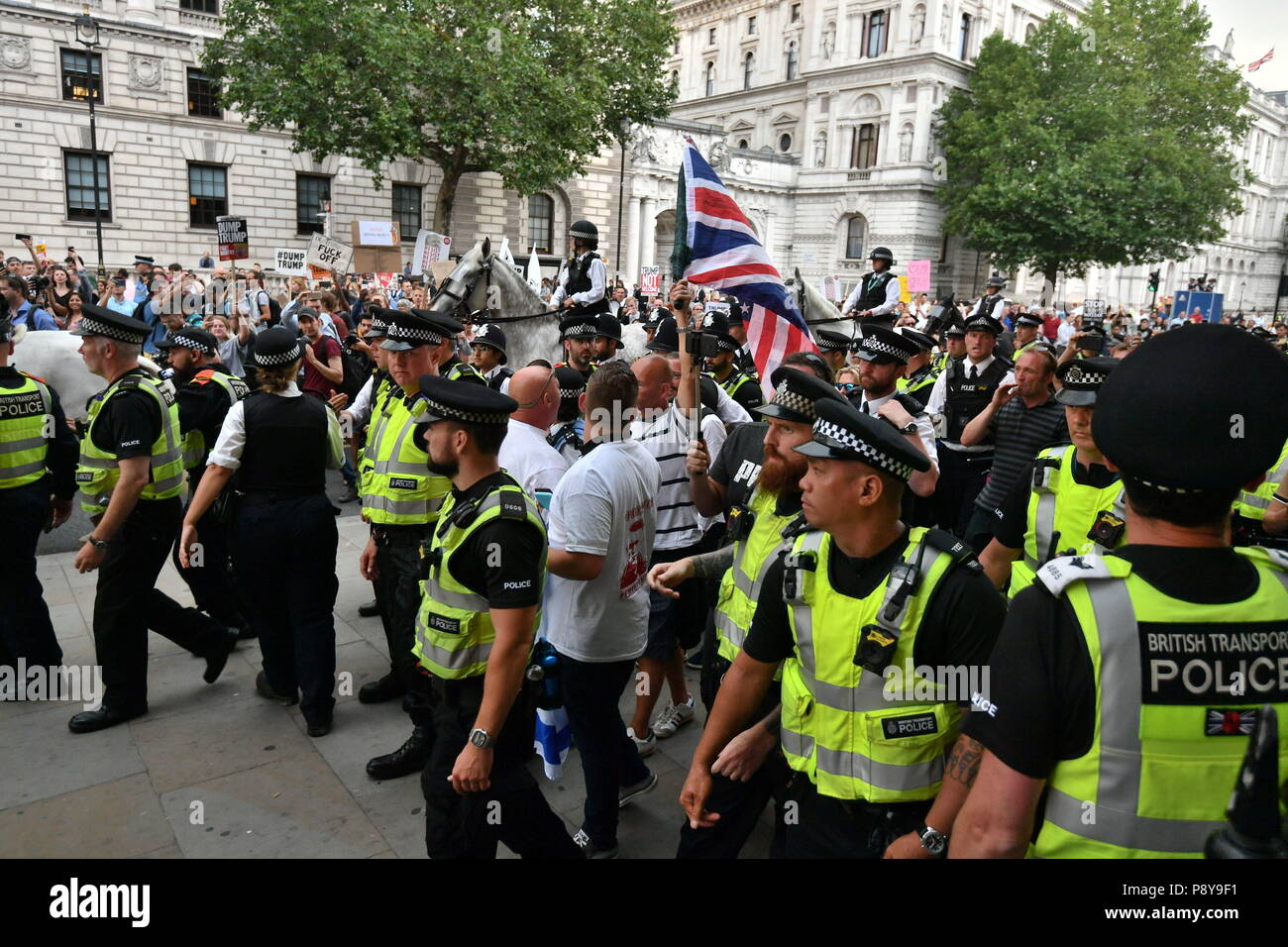 Les membres de la Ligue de défense anglaise sont entourés par la police et sont escortés à travers Westminster jusqu'à la station de métro, loin des foules de manifestants anti-Trump qui s'étaient réunis à Londres pour la marche « Stop Trump ». Banque D'Images