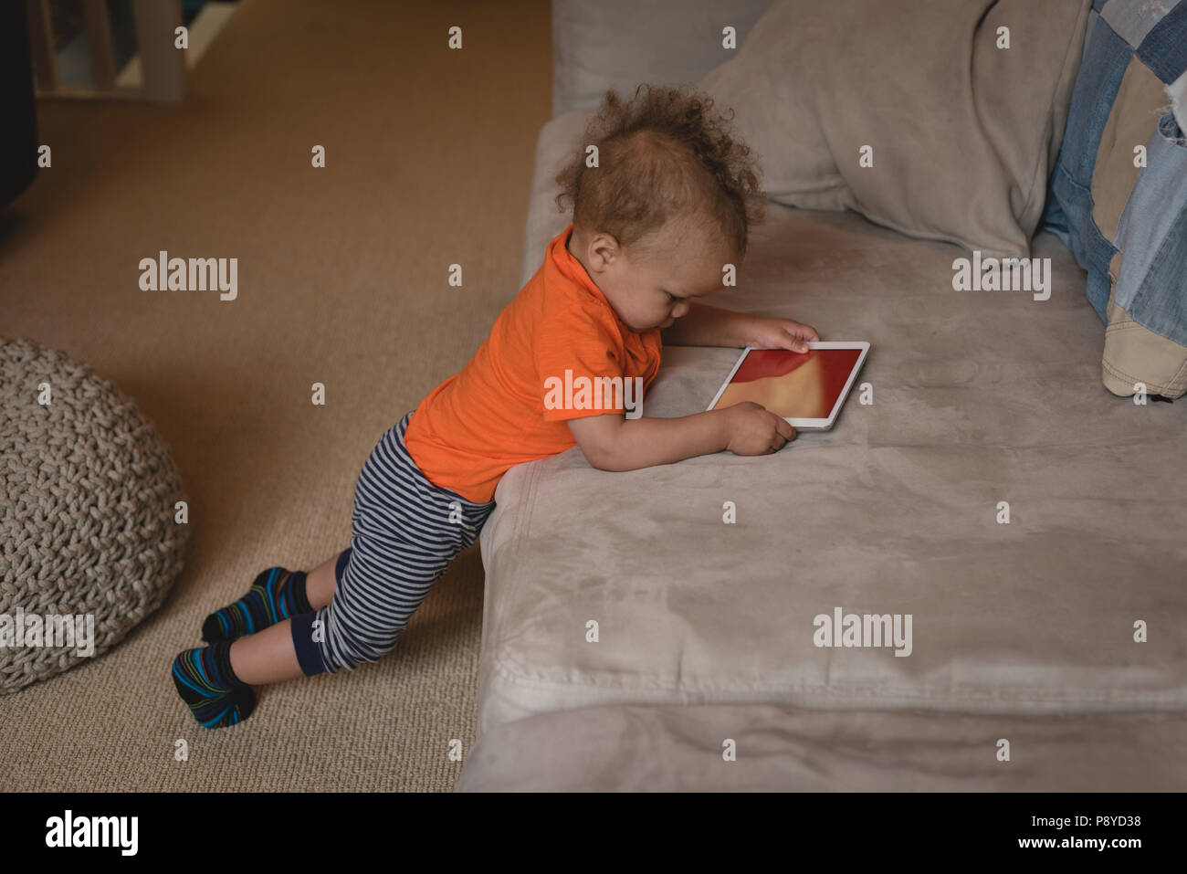 Baby Boy using digital tablet sur le canapé Banque D'Images