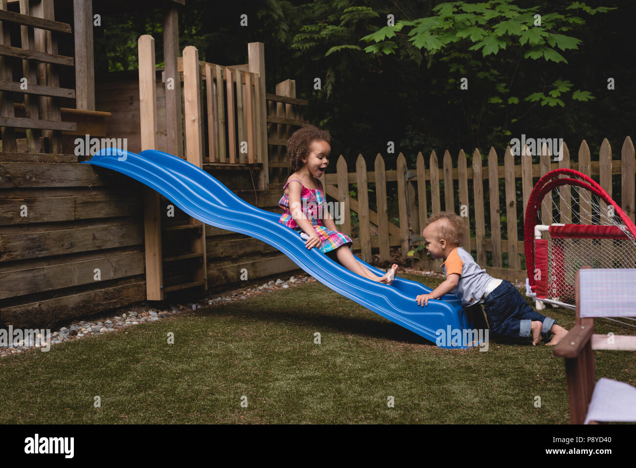 Frères et sœurs jouant dans le jardin Banque D'Images