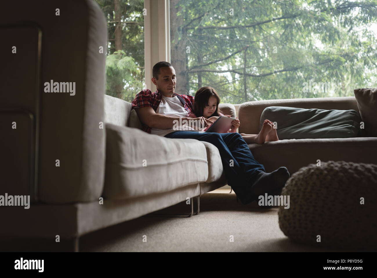 Père et fille using digital tablet in living room Banque D'Images