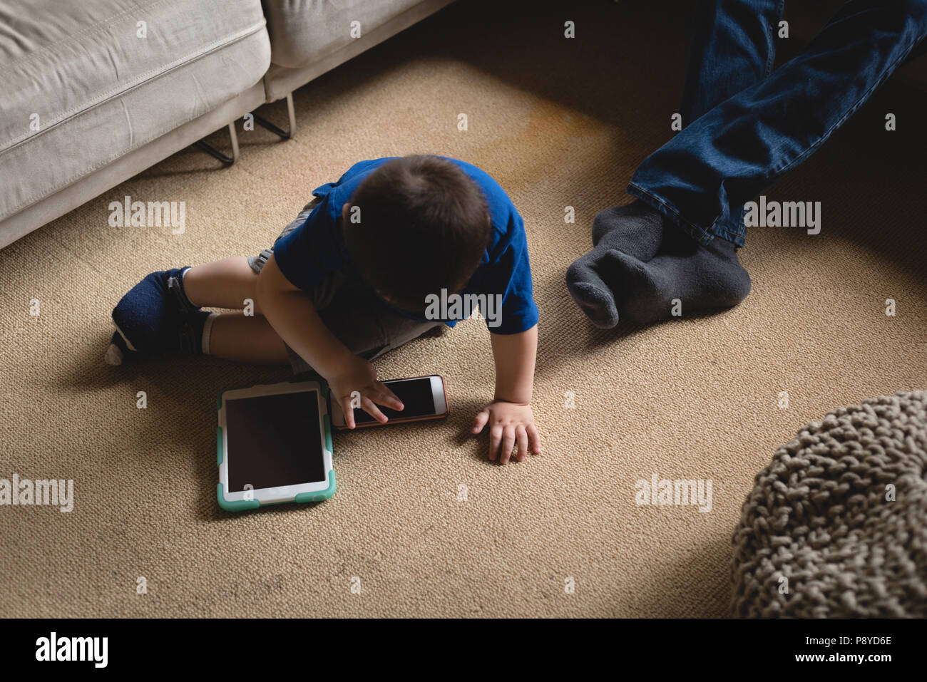 Boy using digital tablet in living room Banque D'Images