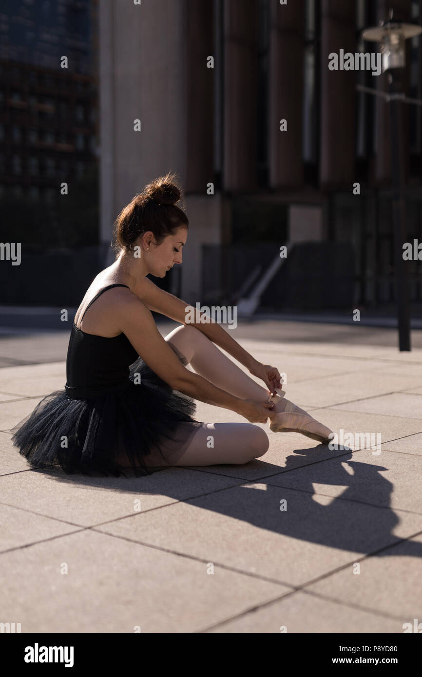 Ballet féminin danseuse attachant le ruban sur son ballet shoes Banque D'Images