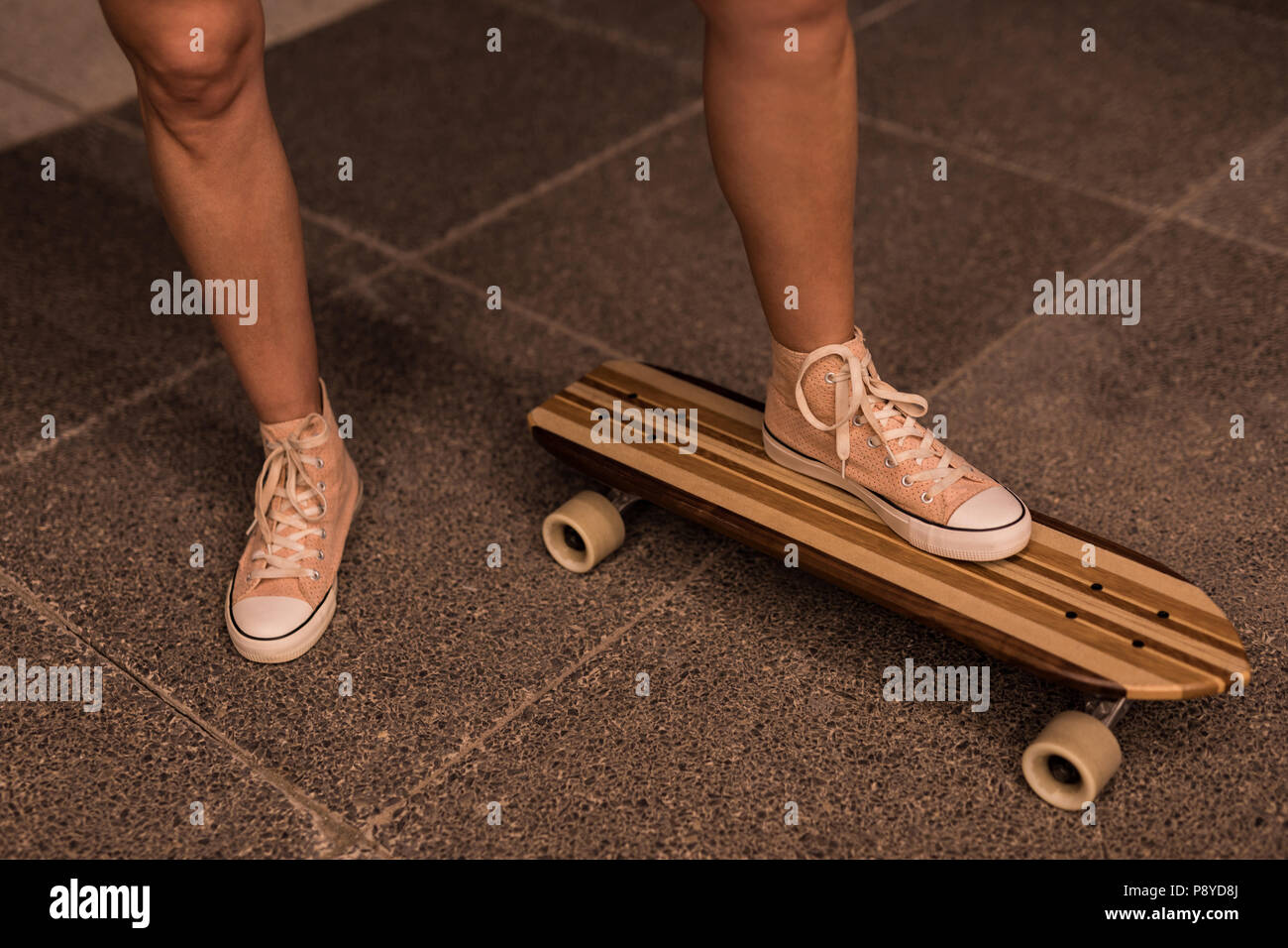 Patineuse femme debout sur le skateboard Banque D'Images