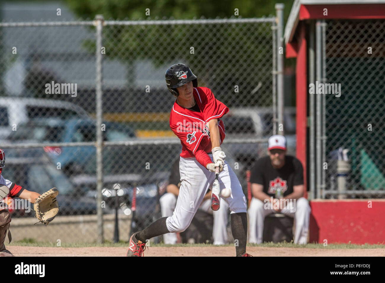 La prestation de Pitcher la hauteur, en pleine course, montrant l'adhérence, les garçons d'après-midi d'un match de baseball junior. Cranbrook, BC. Banque D'Images