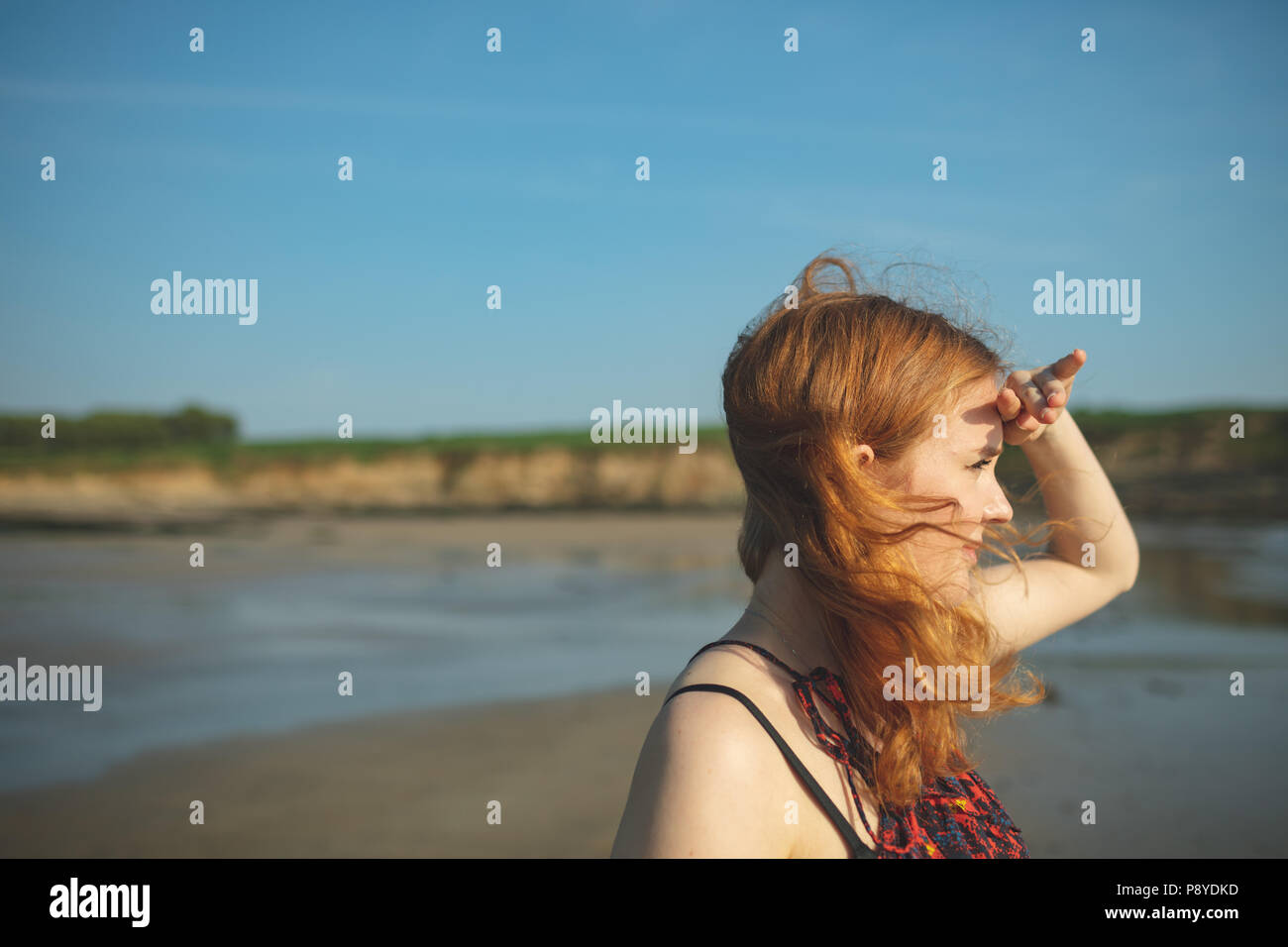 Femme regardant vers la mer sur une journée ensoleillée Banque D'Images