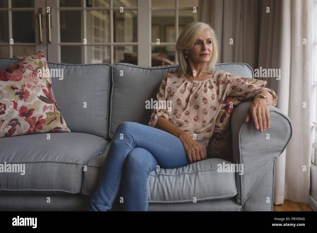 Happy woman sitting on sofa Banque D'Images