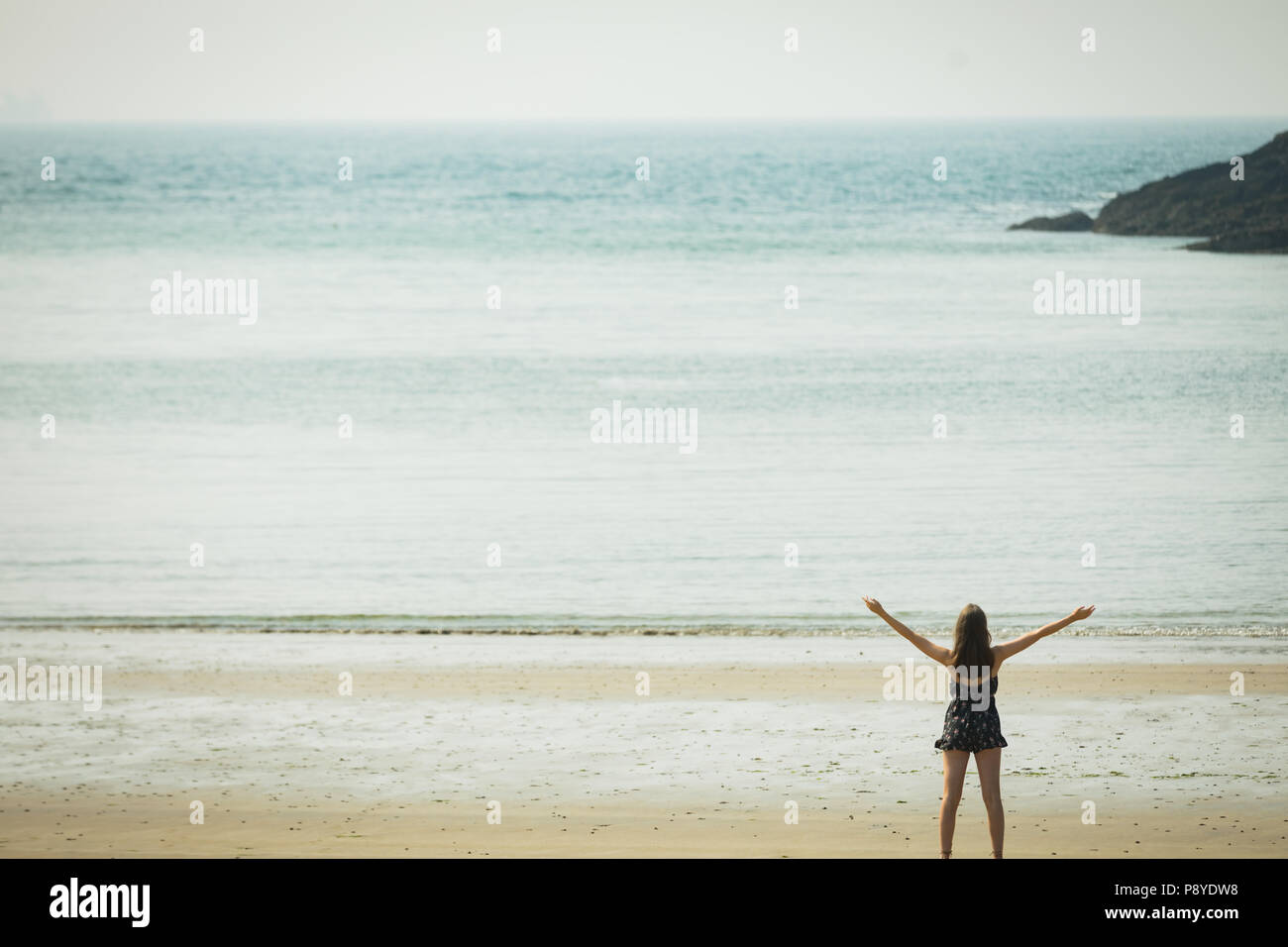 Femme debout sur la plage avec ses mains propagation Banque D'Images