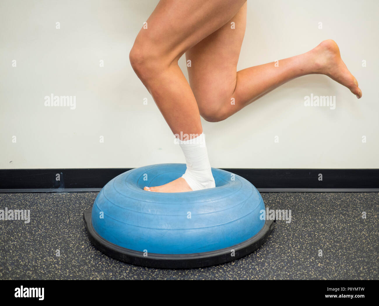 Avec l'athlète faisant une entorse à la cheville et le renforcement des exercices d'équilibre sur un ballon bosu Banque D'Images