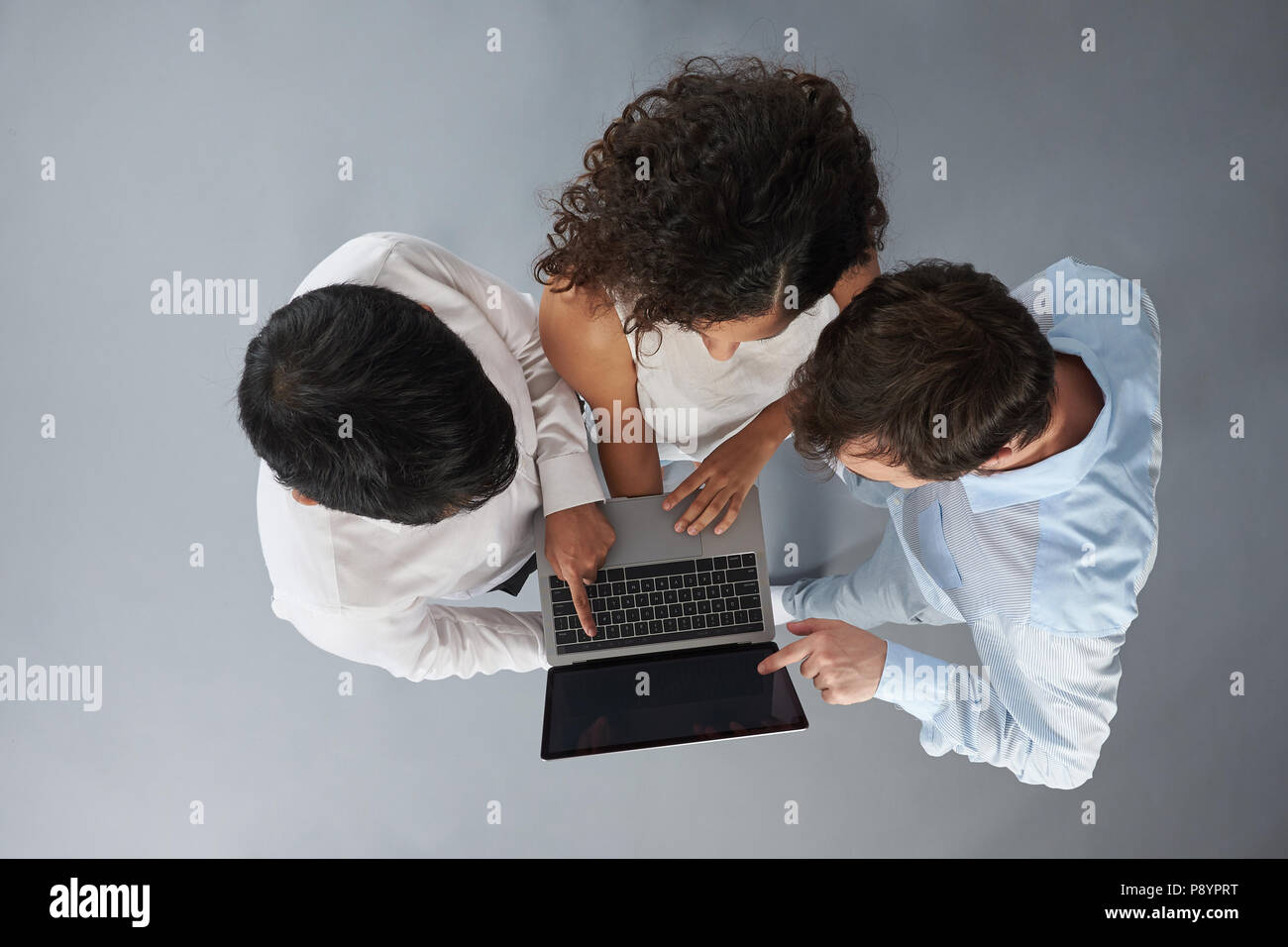 Trois personnes travaillent sur le projet isolé sur fond gris au-dessus (top view) Banque D'Images