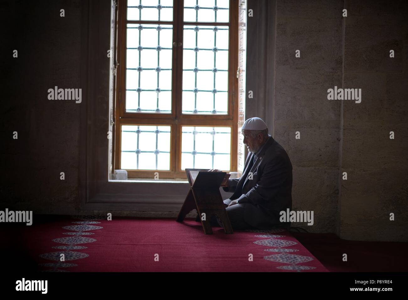 Vieil homme lisant le Coran dans la mosquée, Turquie Banque D'Images