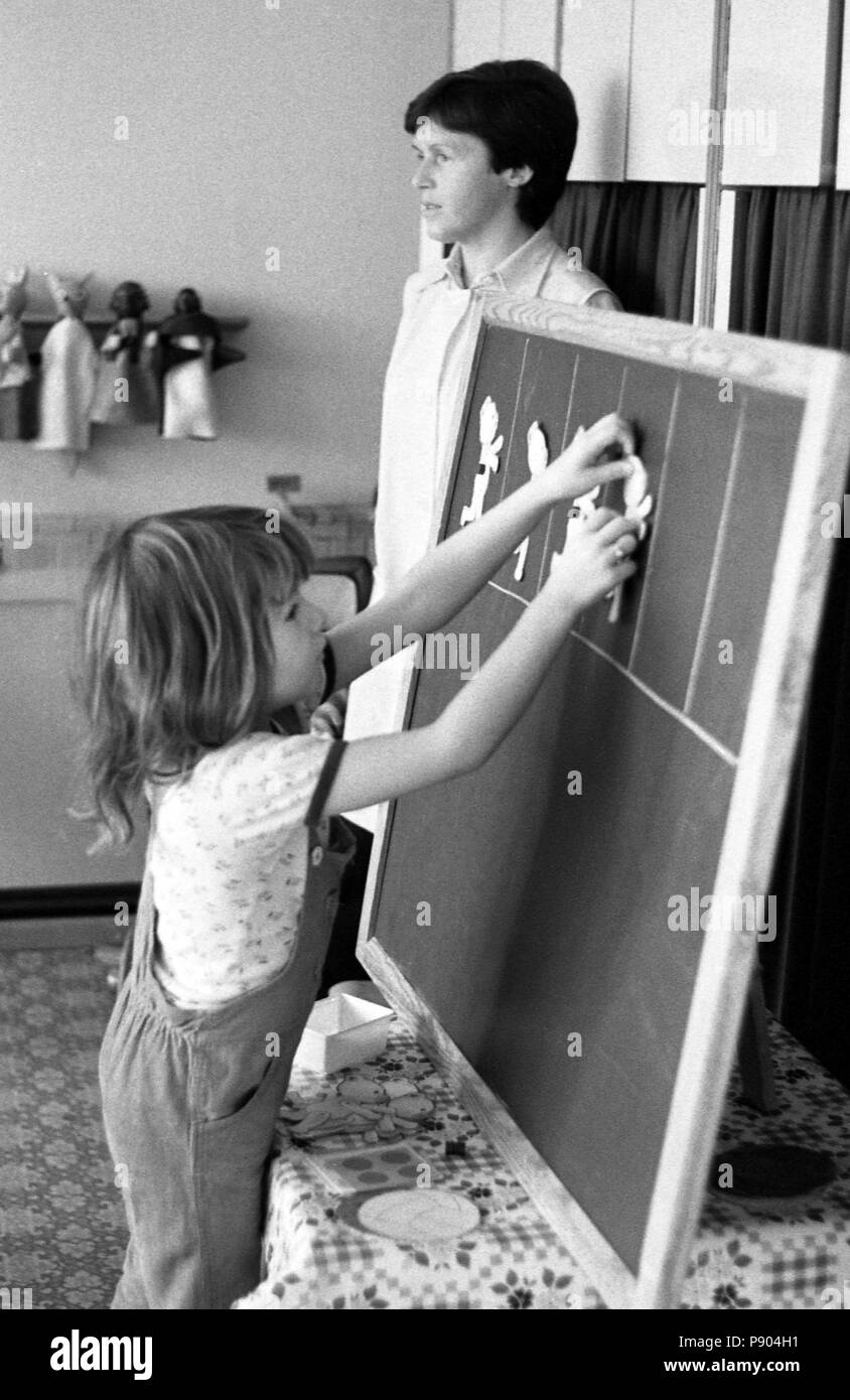 Berlin, RDA, fille coincé dans les chiffres d'âge préscolaire de papier sur un tableau noir Banque D'Images