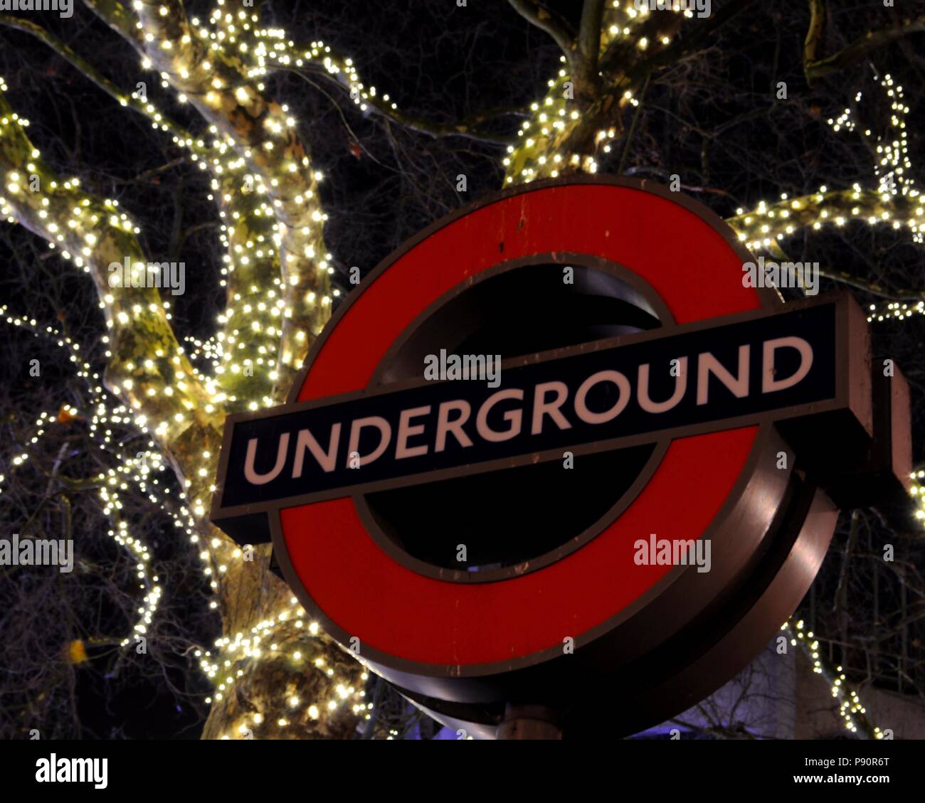 London Underground sign au Museum d'Histoire Naturelle entrée de Kensington sud tunnel pour piétons avec des lumières de Noël en arrière-plan, Londres, Royaume-Uni. Banque D'Images