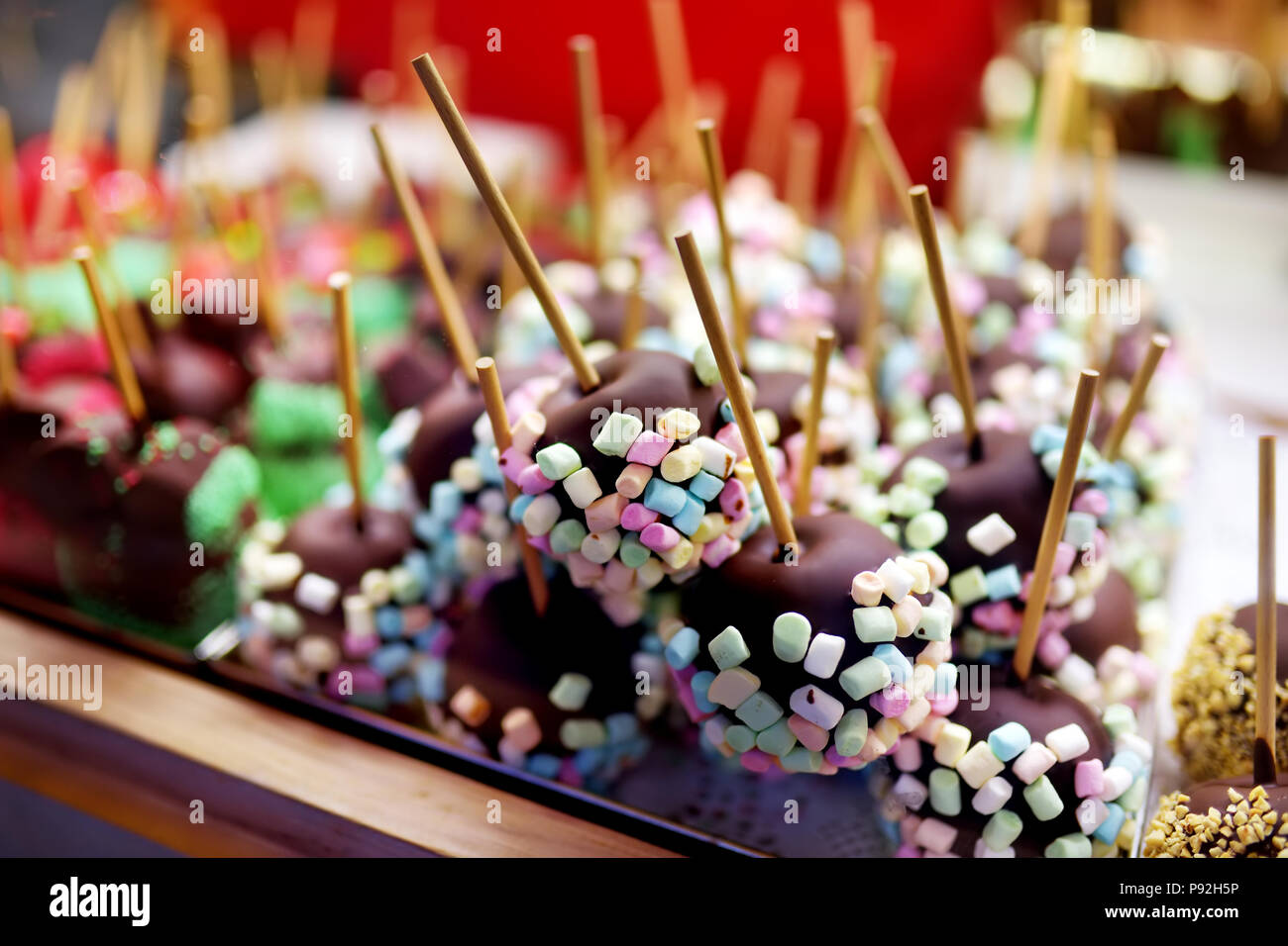 Plongeon dans les pommes et glaçage au chocolat petites guimauves vendus sur le marché de Noël. Les bonbons, les sucreries et les desserts sur le temps de Noël. Vacances d'hiver à l'extérieur. Banque D'Images