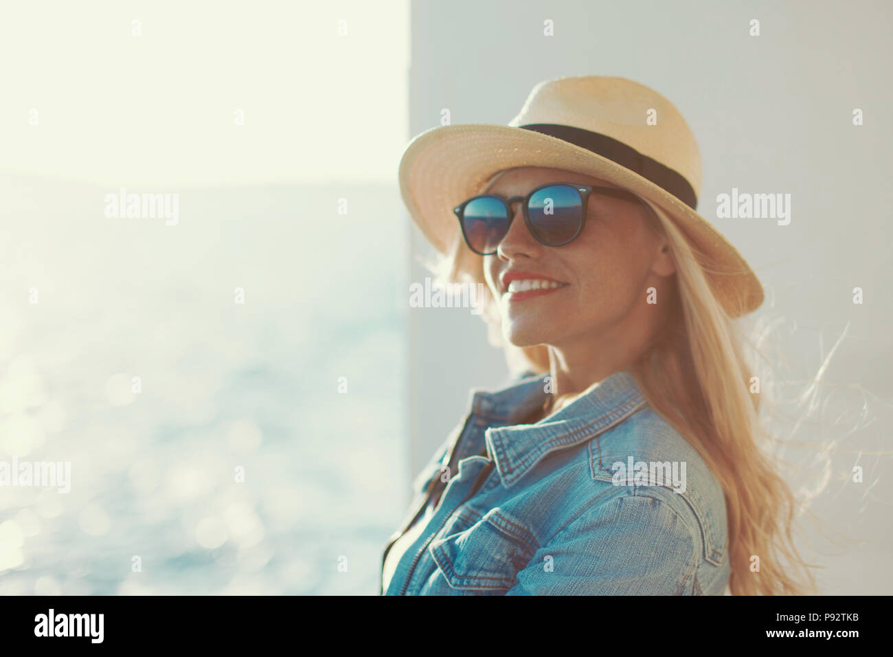 Happy young blonde woman in hat voyageur on cruise ship Banque D'Images