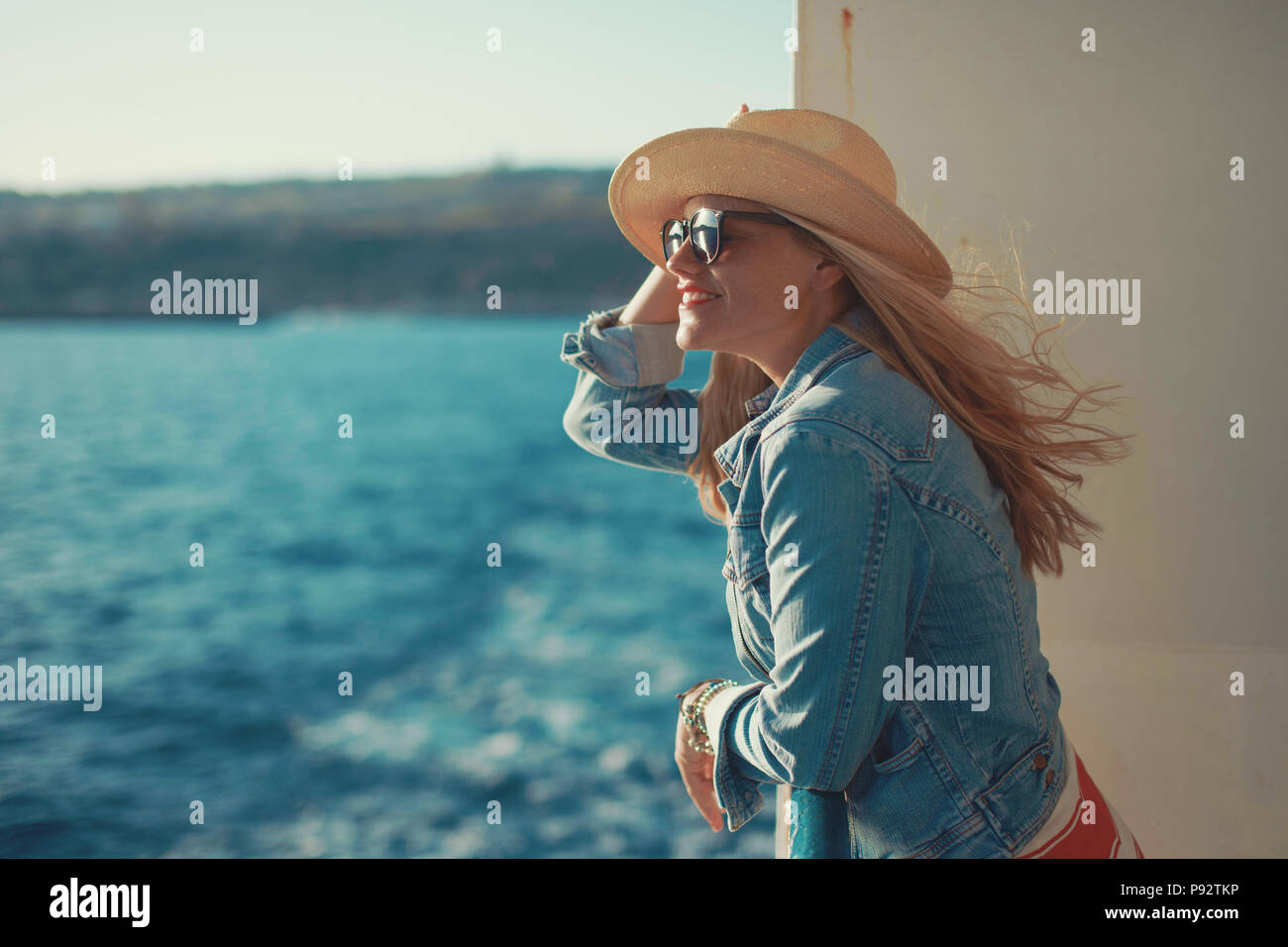 Jeune femme blonde traveler sur mer à hat looking away Banque D'Images