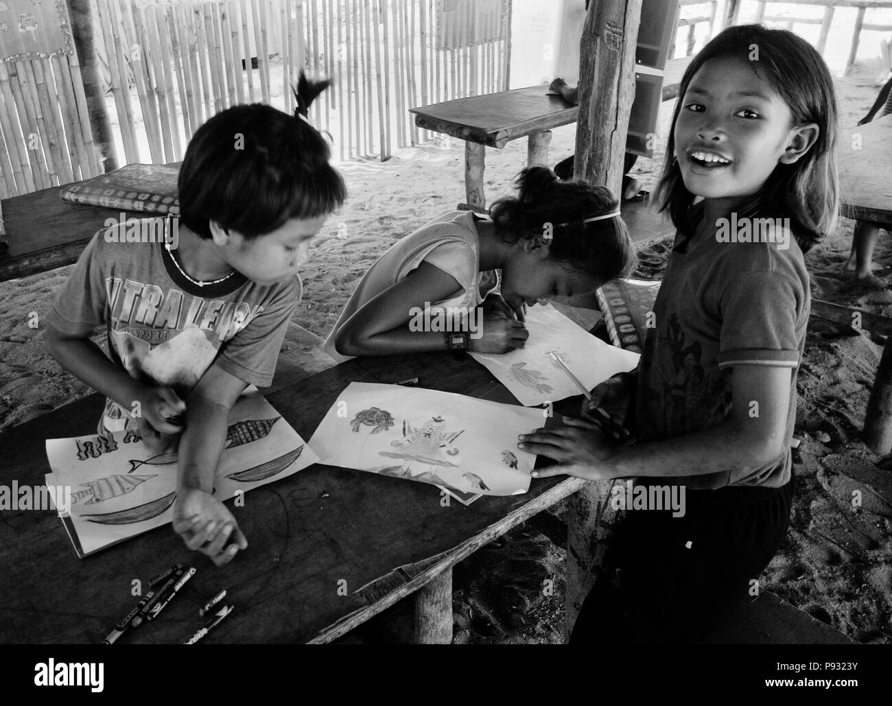 Filles Moken (gitans de la mer) de rendre l'art à l'école dans leur village sur Ko Surin île thaïlandaise dans le Parc National de Mu Koh Surin - la mer d'Andaman, Thaïlande Banque D'Images