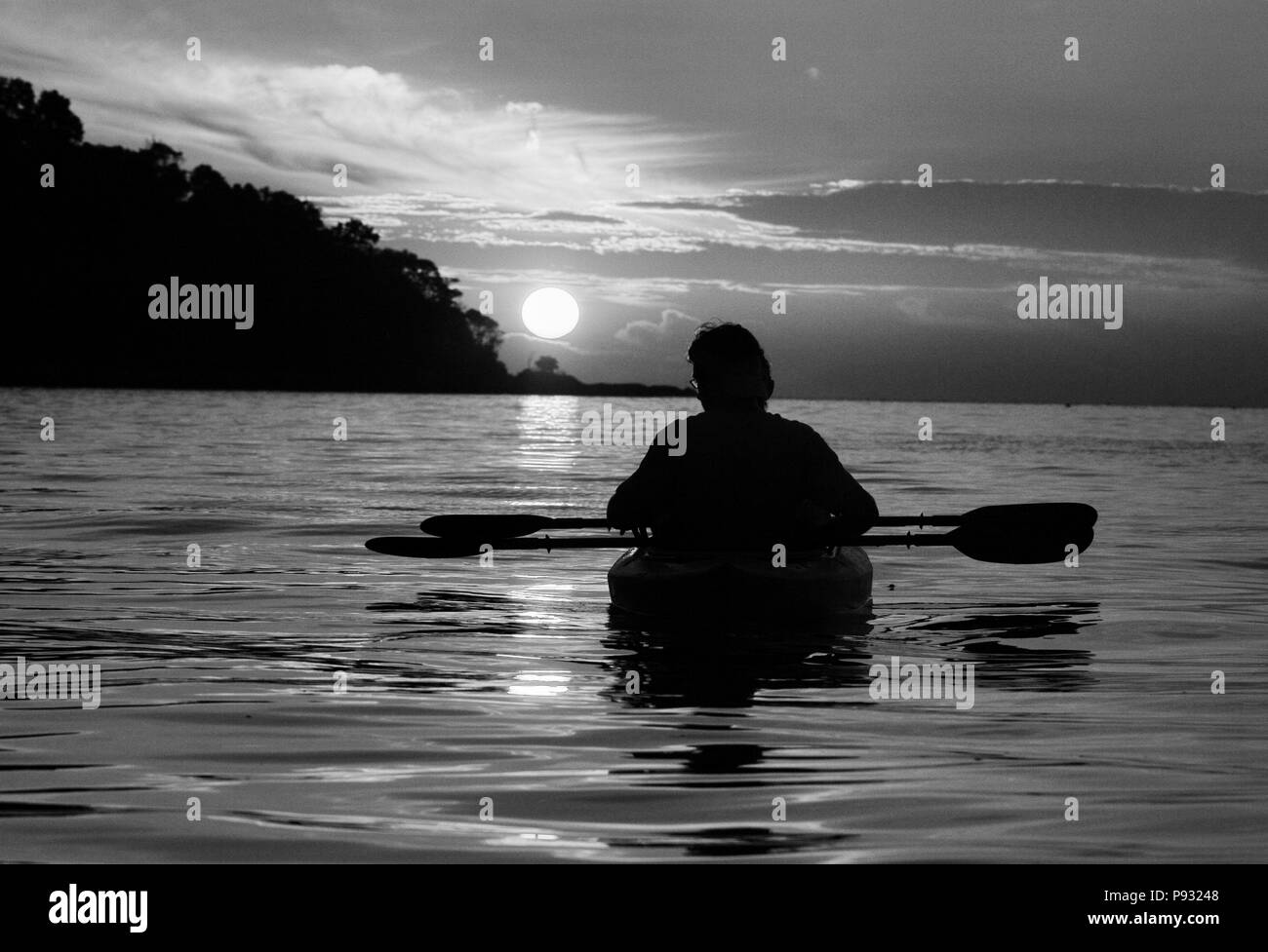 Les kayakistes profiter d'un lever du soleil tropical sur le Nord de la mer d'Andaman au large de la côte de Ko Surin Nuea Île dans le Parc National de Mu Koh Surin, Thaïlande Banque D'Images