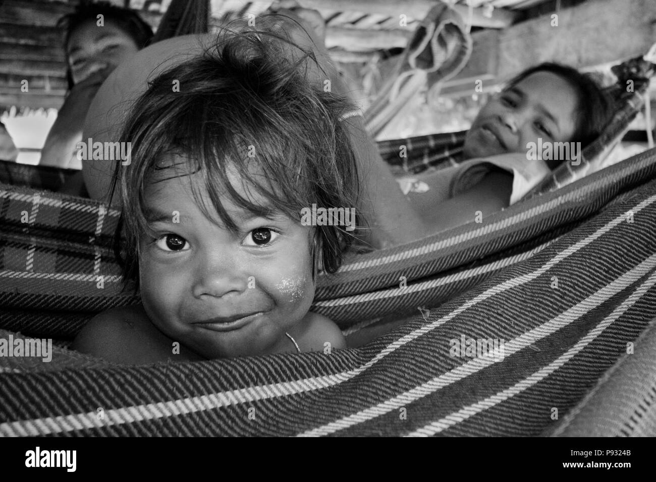 (Moken sea gypsy) enfant balançoires dans un hamac dans son village sur Ko Surin île thaïlandaise dans le Parc National de Mu Koh Surin - la mer d'Andaman, Thaïlande Banque D'Images