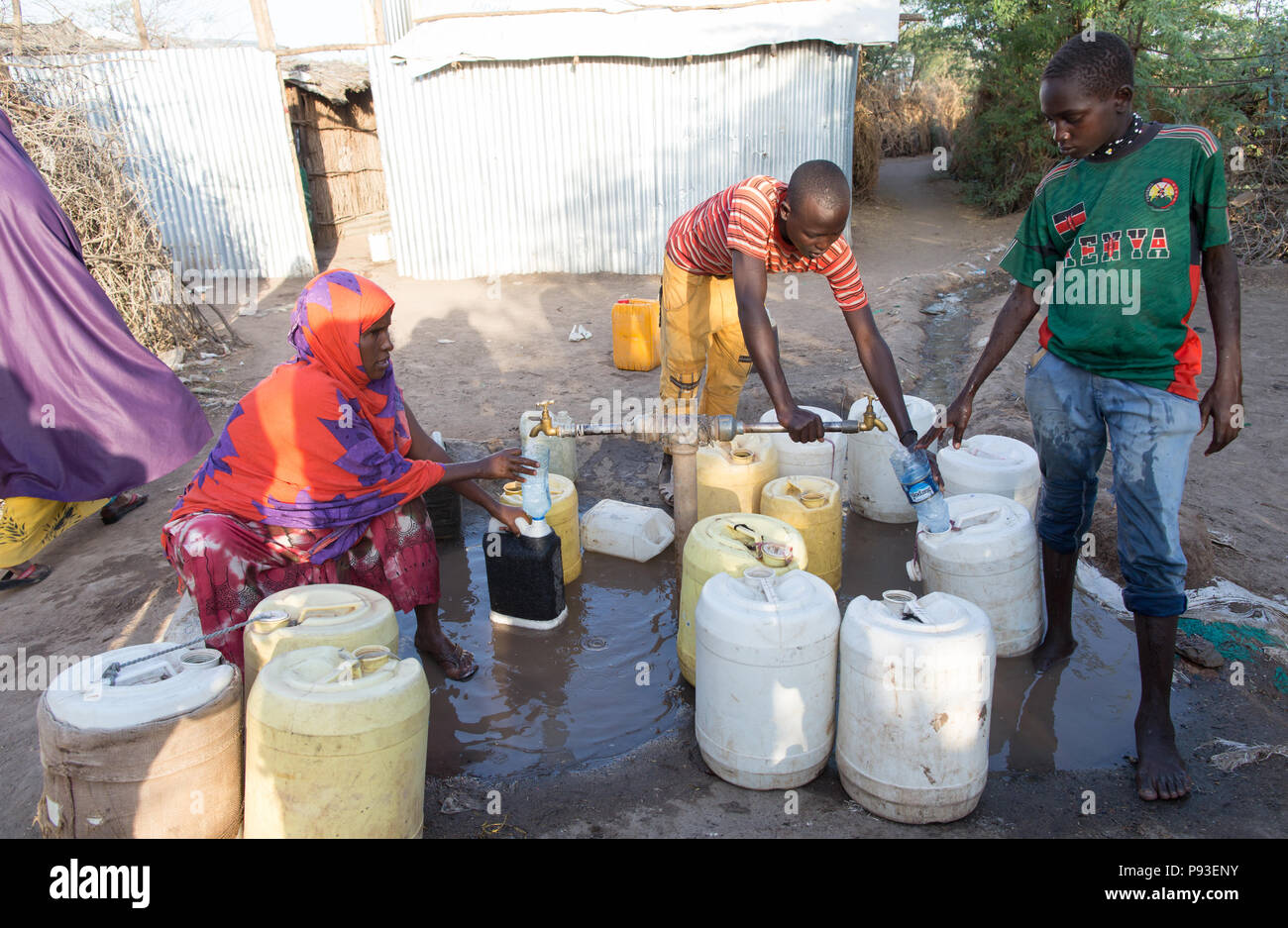 Kakuma, Kenya - dans le camp de réfugiés de Kakuma, les réfugiés versez de l'eau dans des bidons à une station de charge. Banque D'Images