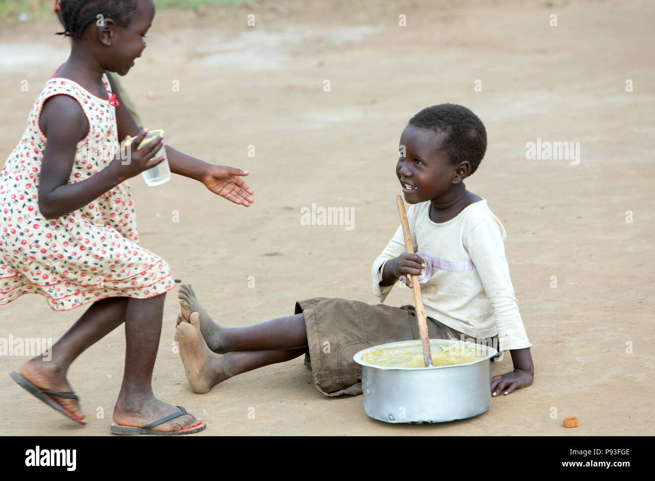 Kamdini, Ouganda - la vie à la campagne. Les enfants jouent à la cuisson. Banque D'Images